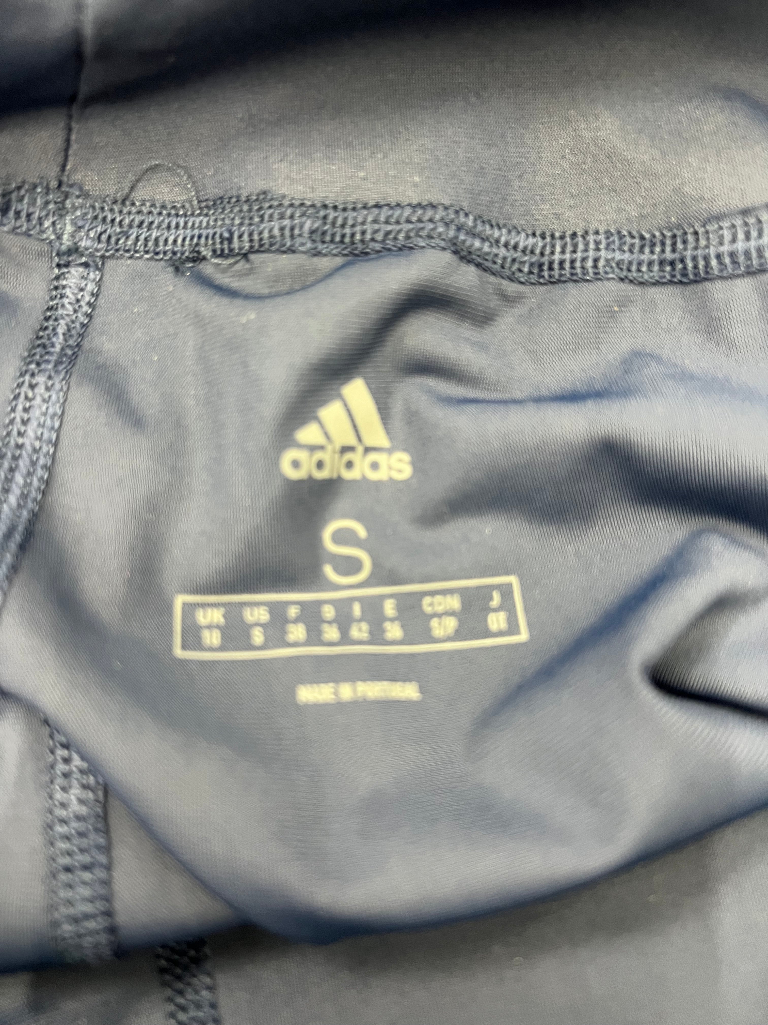 Close-up of Adidas inner size label showing size Small with multiple region size conversions
