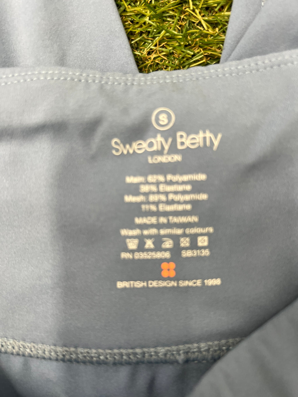 Close-up of Sweaty Betty label and fabric composition inside waistband of pale grey leggings