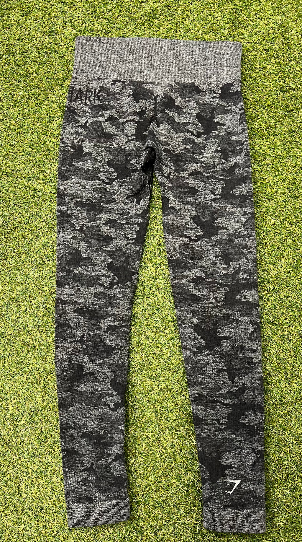 Back view of Gymshark grey camouflage active leggings showing logo on ankle and waistband