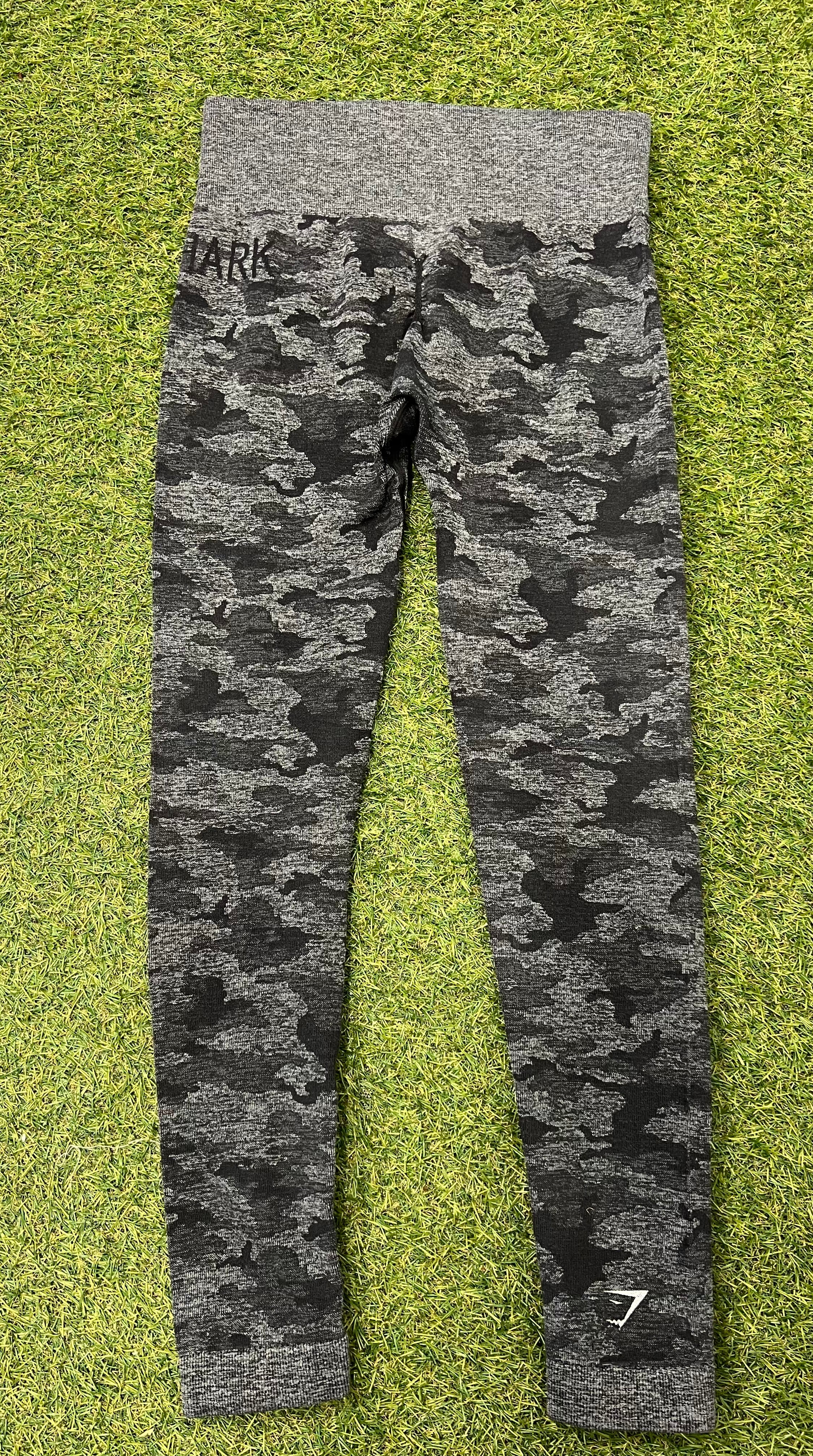 Back view of Gymshark grey camouflage active leggings showing logo on ankle and waistband