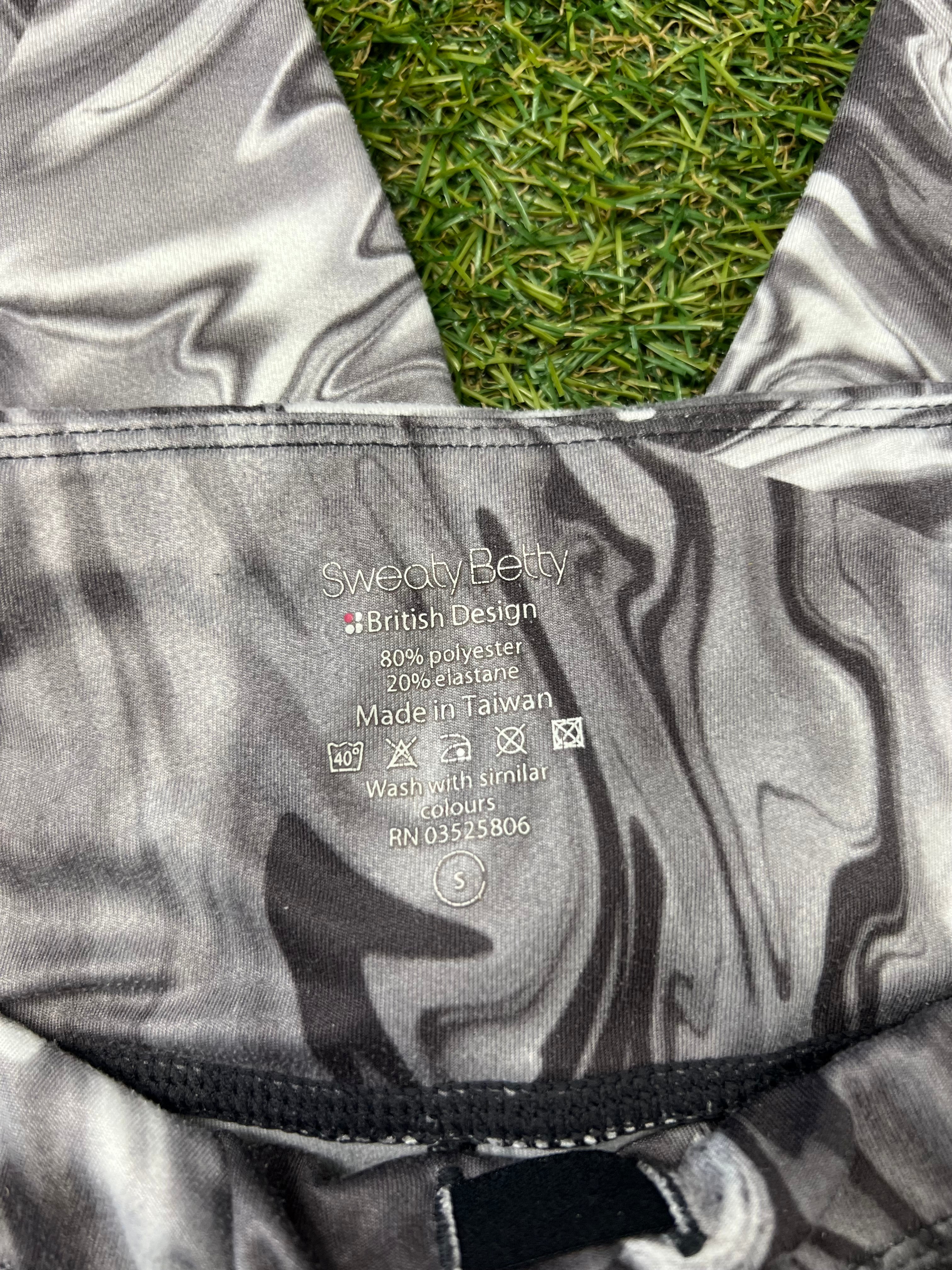 Close-up of inside label on grey black marbled Sweaty Betty leggings, showing fabric composition and care instructions