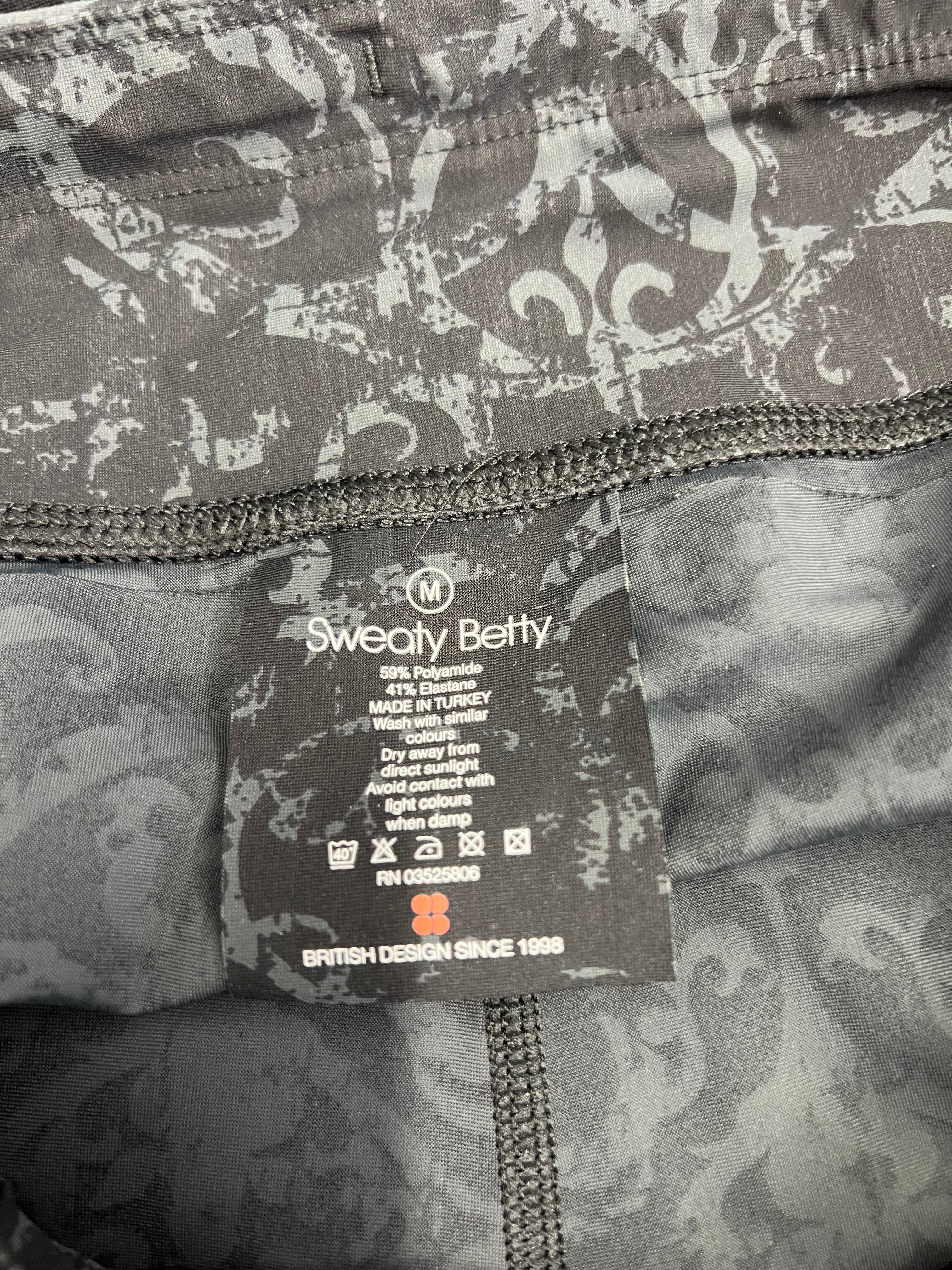 Close-up of inner label inside black and grey printed Sweaty Betty leggings showing fabric composition and care instructions
