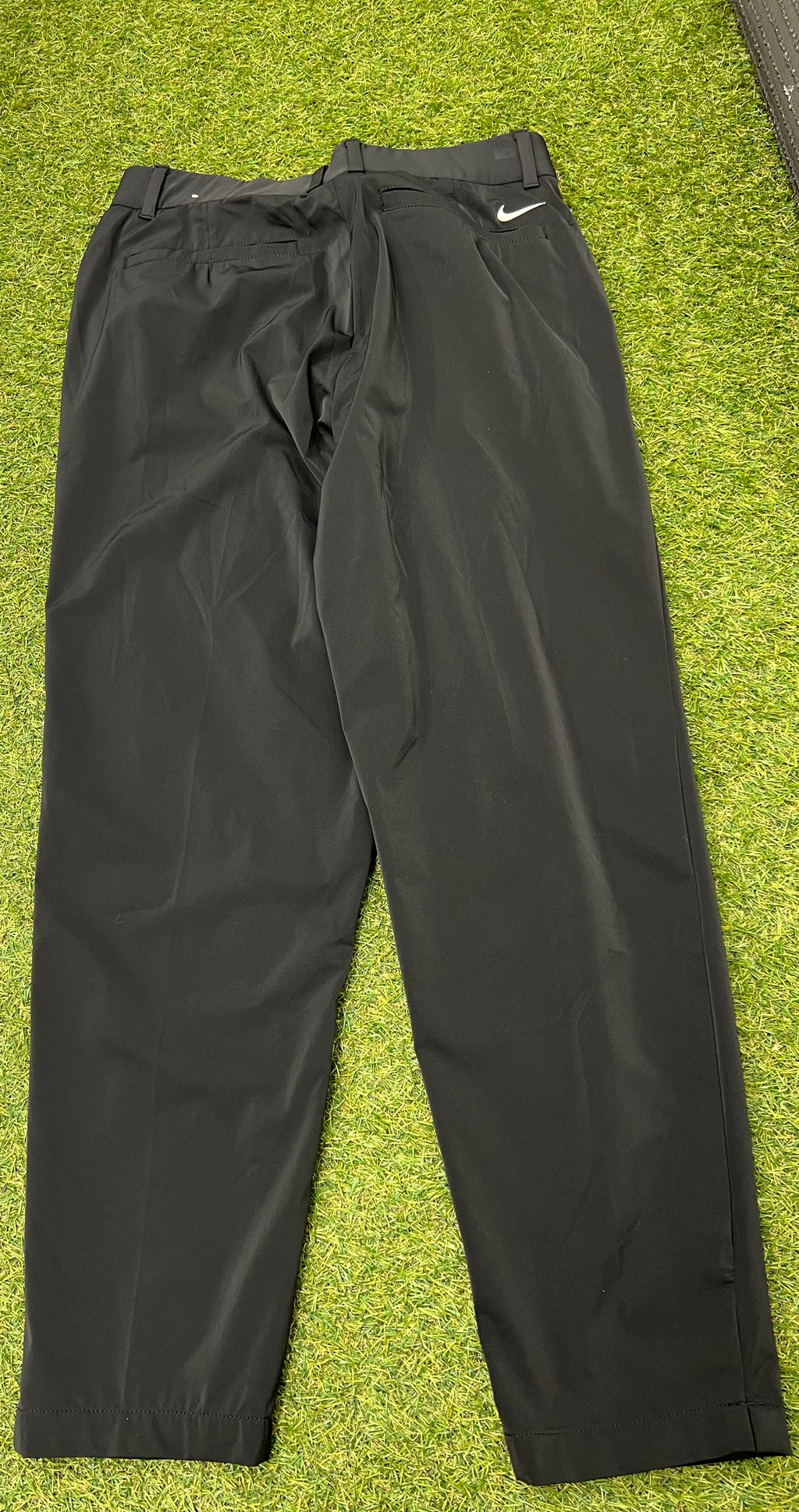 Back view of black Nike women's sports trousers showing pockets and Nike logo