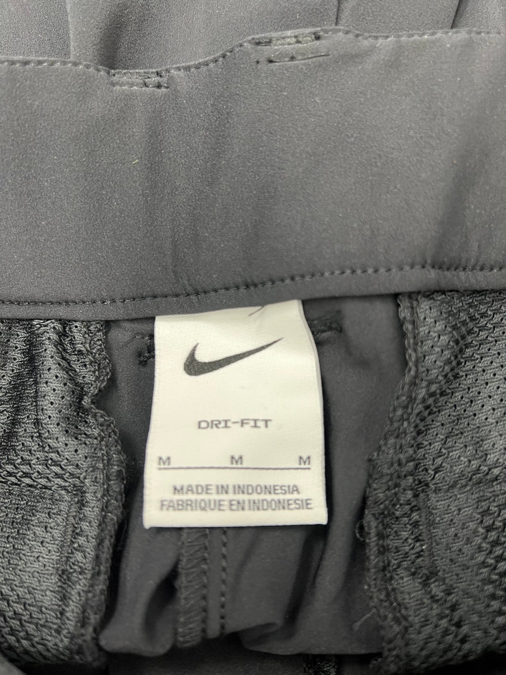 Close-up of Nike Dri-FIT label inside the waistband of black sports trousers