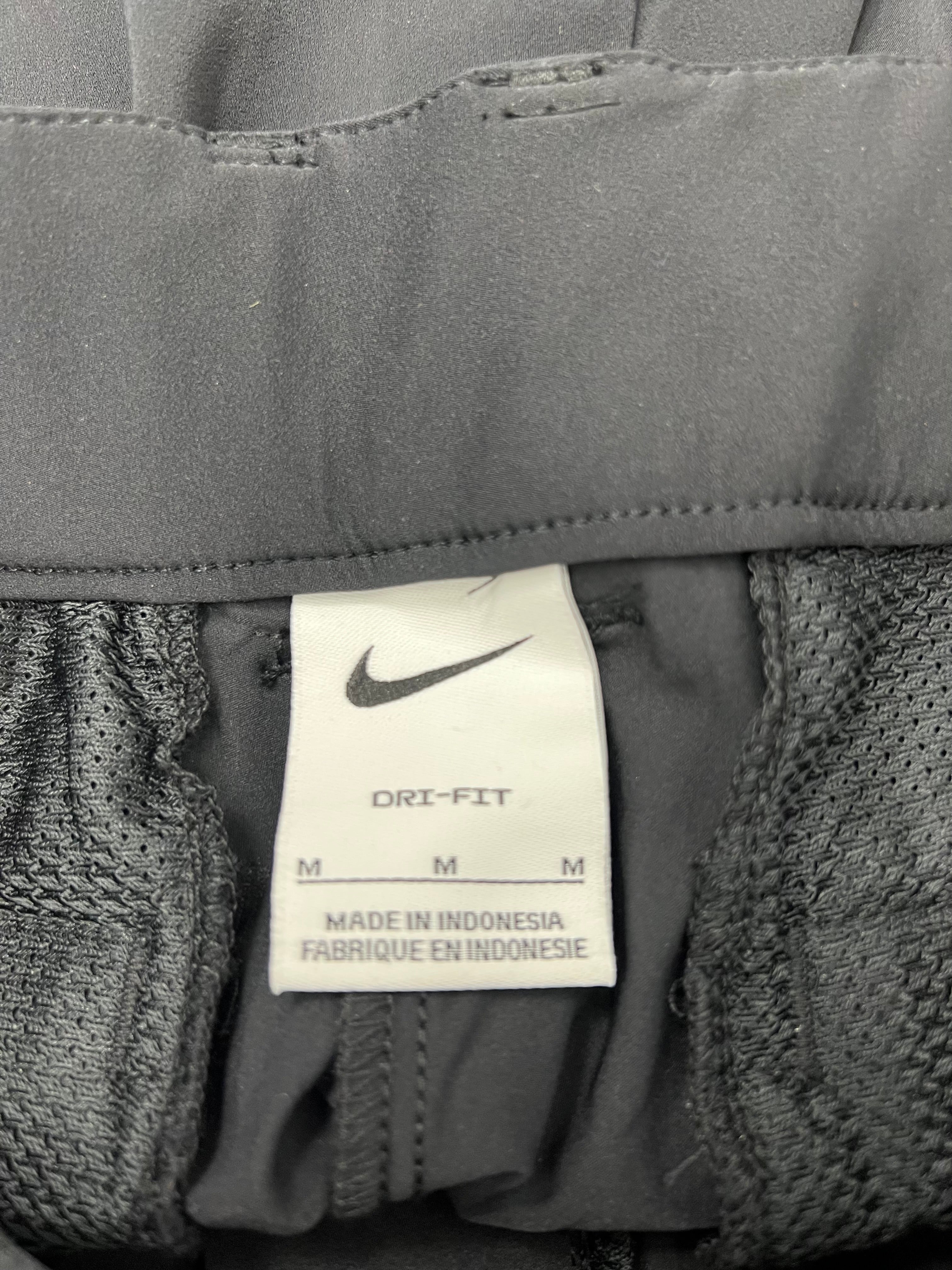 Close-up of Nike Dri-FIT label inside the waistband of black sports trousers