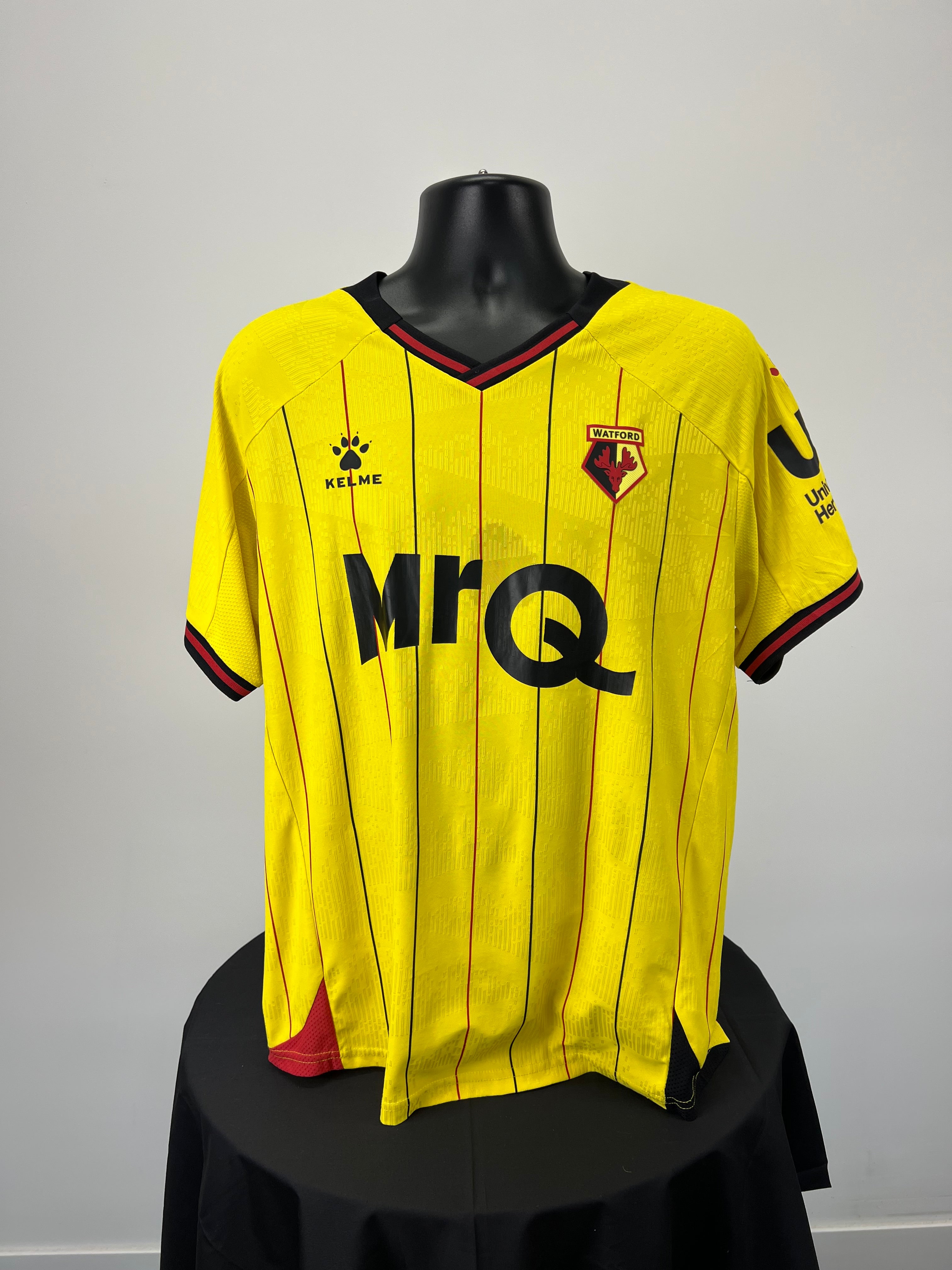 Front view of yellow Watford FC home football shirt with thin black and red pinstripes, Kelme logo, club crest, and MrQ sponsor on the chest