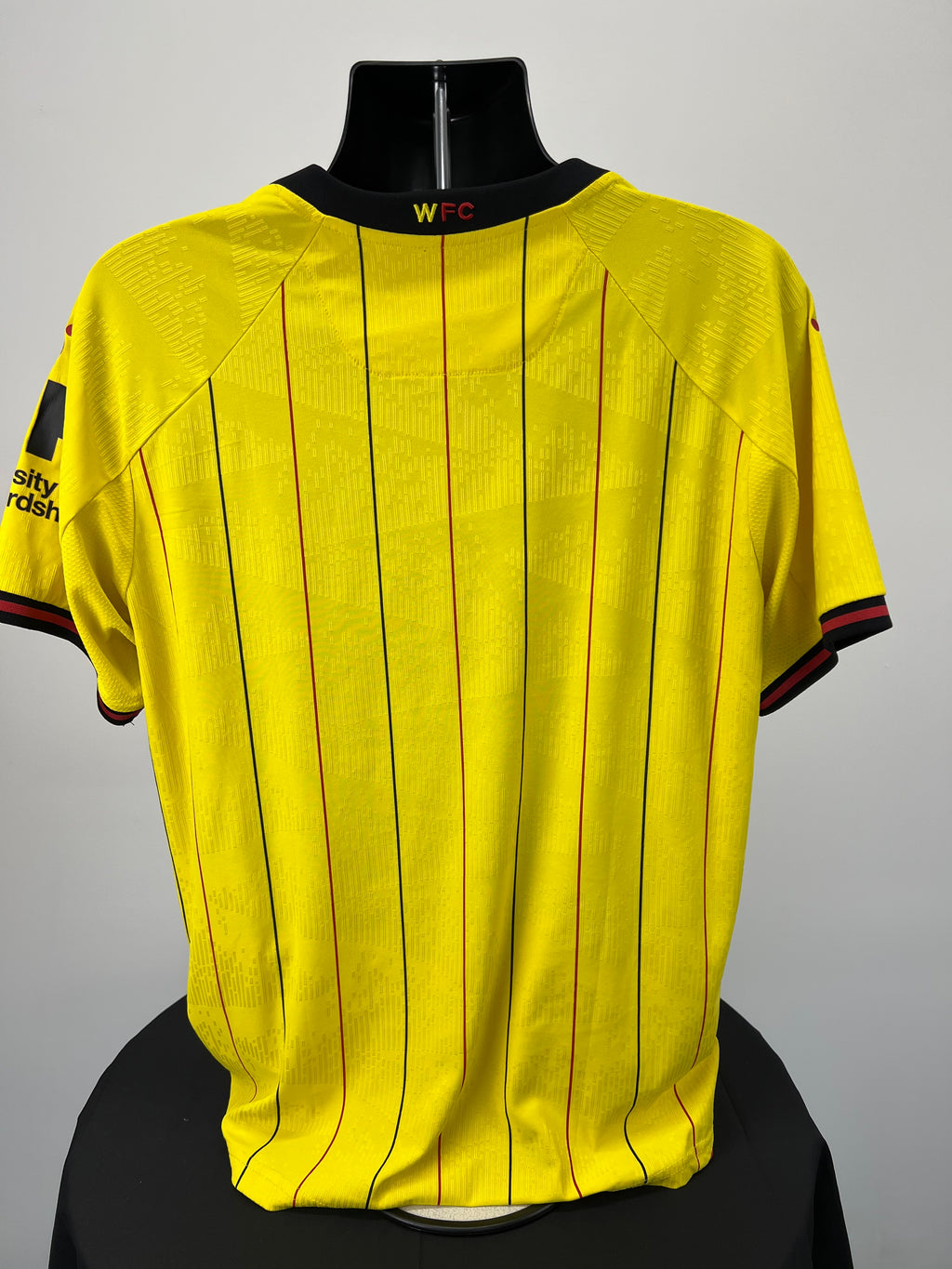 Back view of Watford FC football shirt showing yellow base with black and red pinstripes and WFC embroidery on the collar