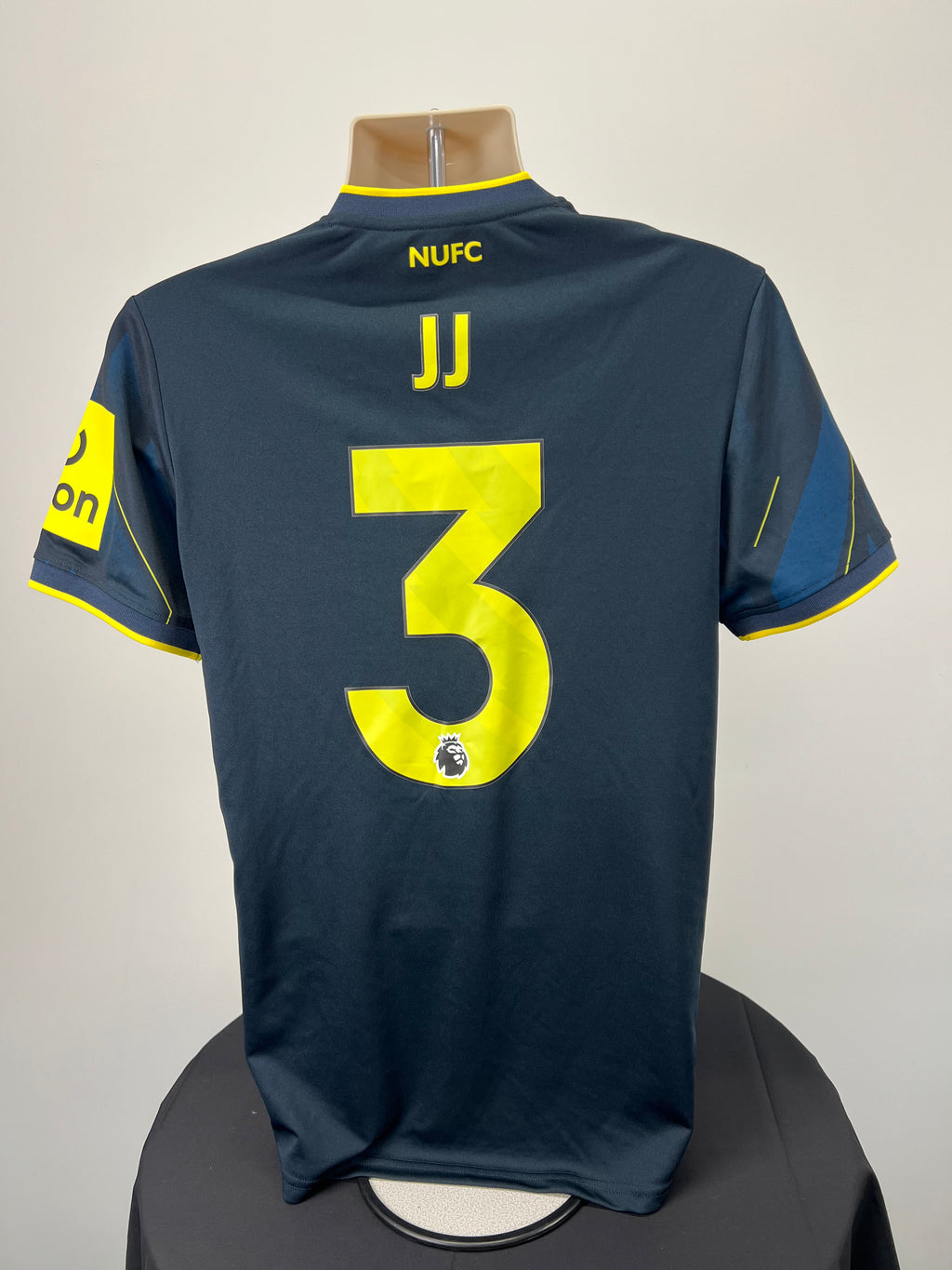 Back view of Newcastle United football shirt showing player initials JJ and number 3 in bright yellow