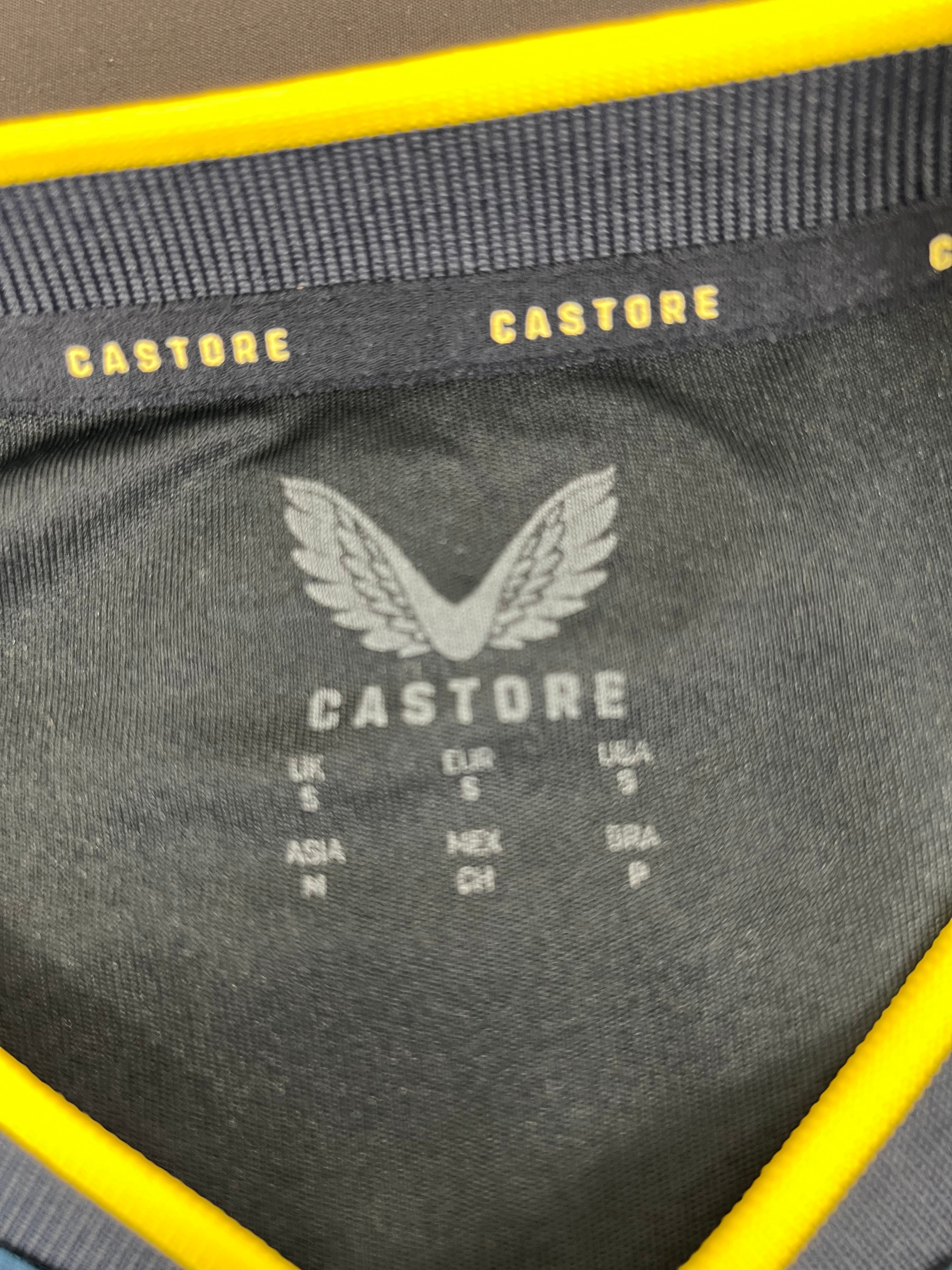 Inside neck label of Newcastle United football shirt by Castore showing size and brand printing