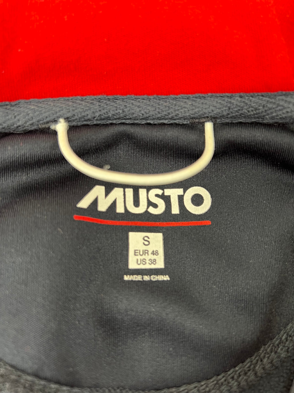 Close-up of the Musto brand label and size information printed inside the jacket collar