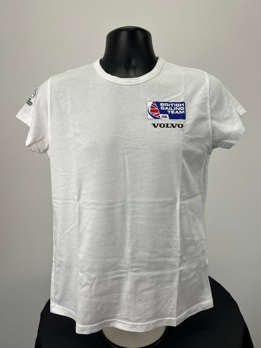 Front view of white Musto British Sailing Team T-shirt with British Sailing Team and Volvo logos on chest