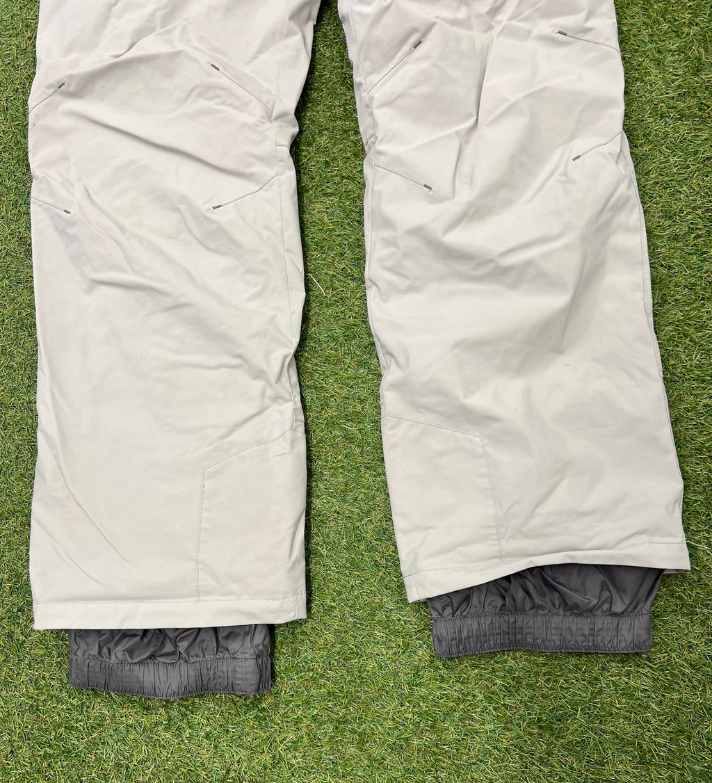 Close-up of Lafuma logo printed on the front thigh area of the light grey ski trousers