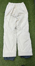 Back view of cream Helly Hansen women's ski trousers laid flat on grass highlighting elasticated waistband and rear stitching