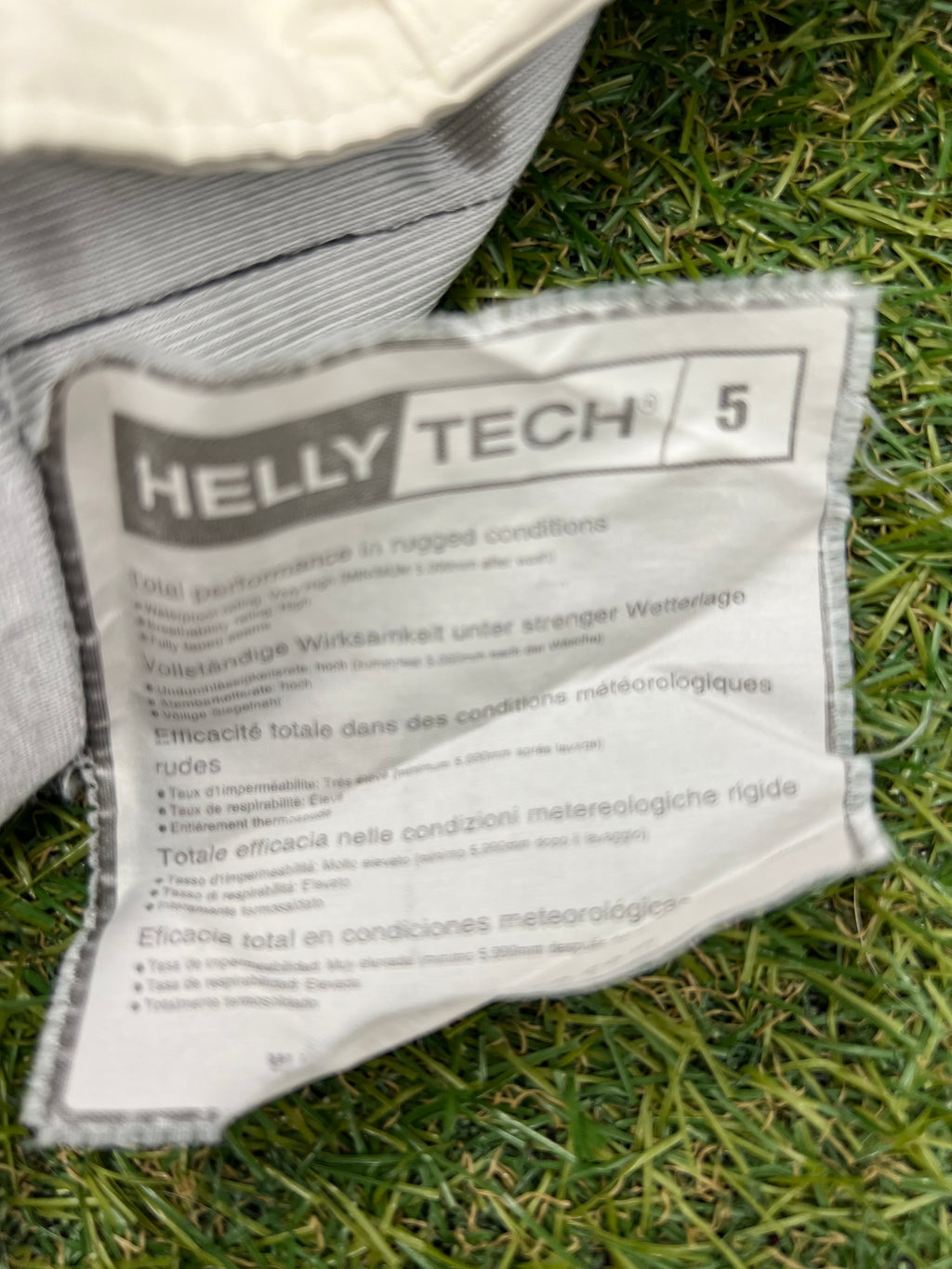 Close-up of care label inside ski trousers detailing Helly Tech® 5 waterproof and breathable technology specifications