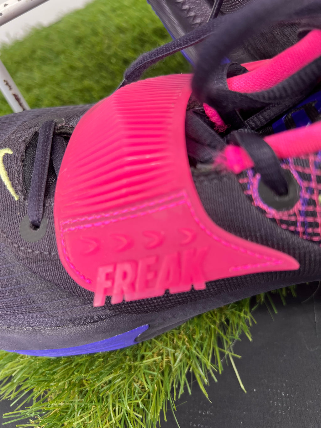 Close-up of the pink midfoot strap with embossed text 'FREAK' on Nike Zoom Freak 3 basketball trainers