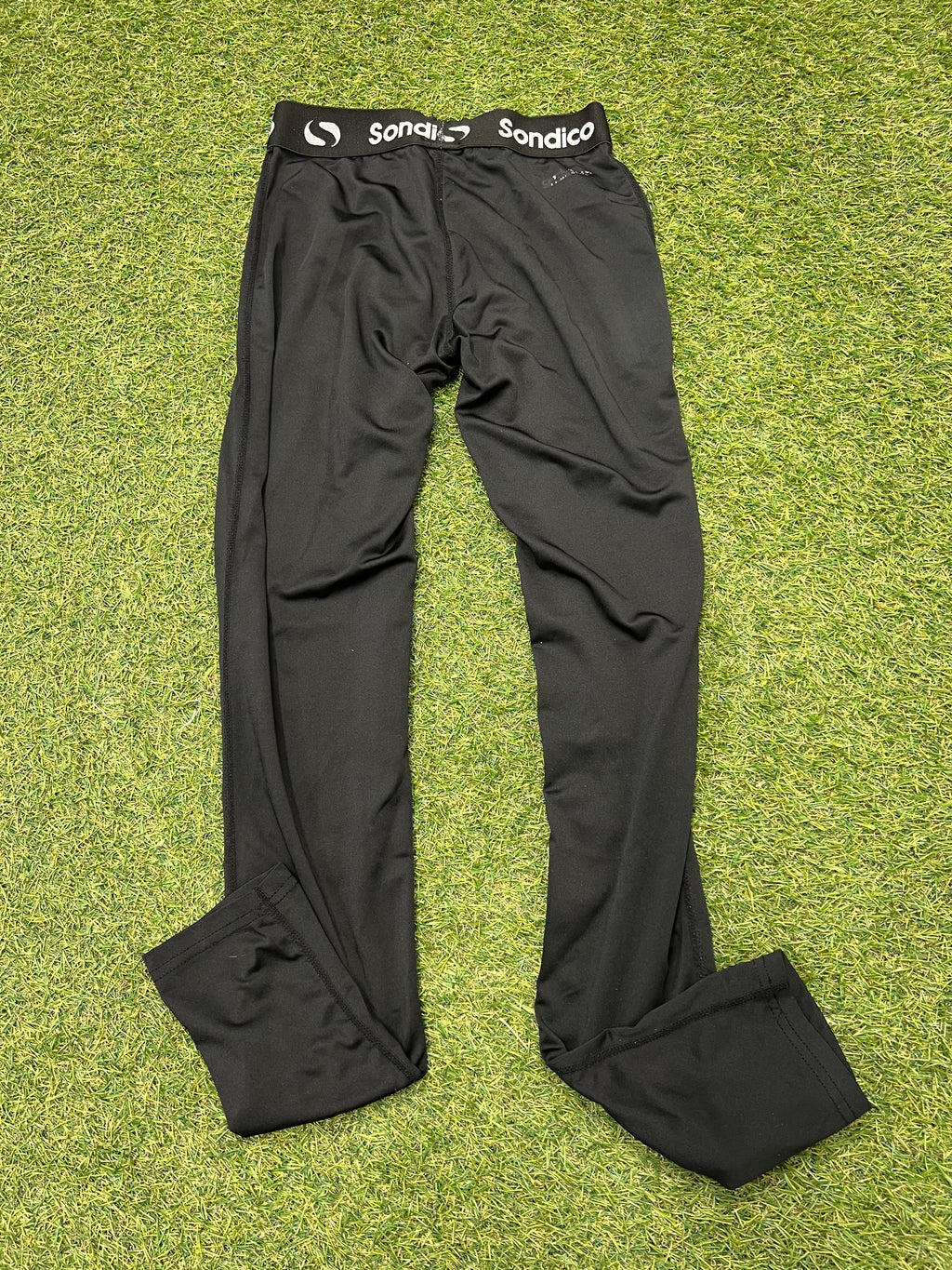 Sondico size label inside black leggings showing UK size 13 years with safety warning text.