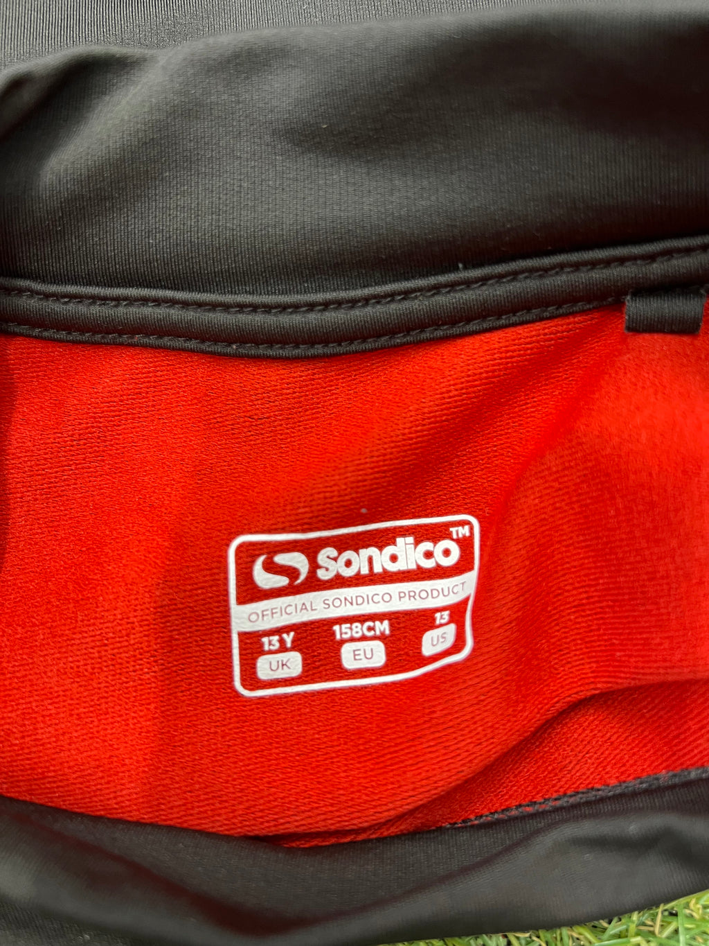 Sondico logo printed inside waist of kids leggings showing UK 13 years, EU 158 cm and US 13 sizes.