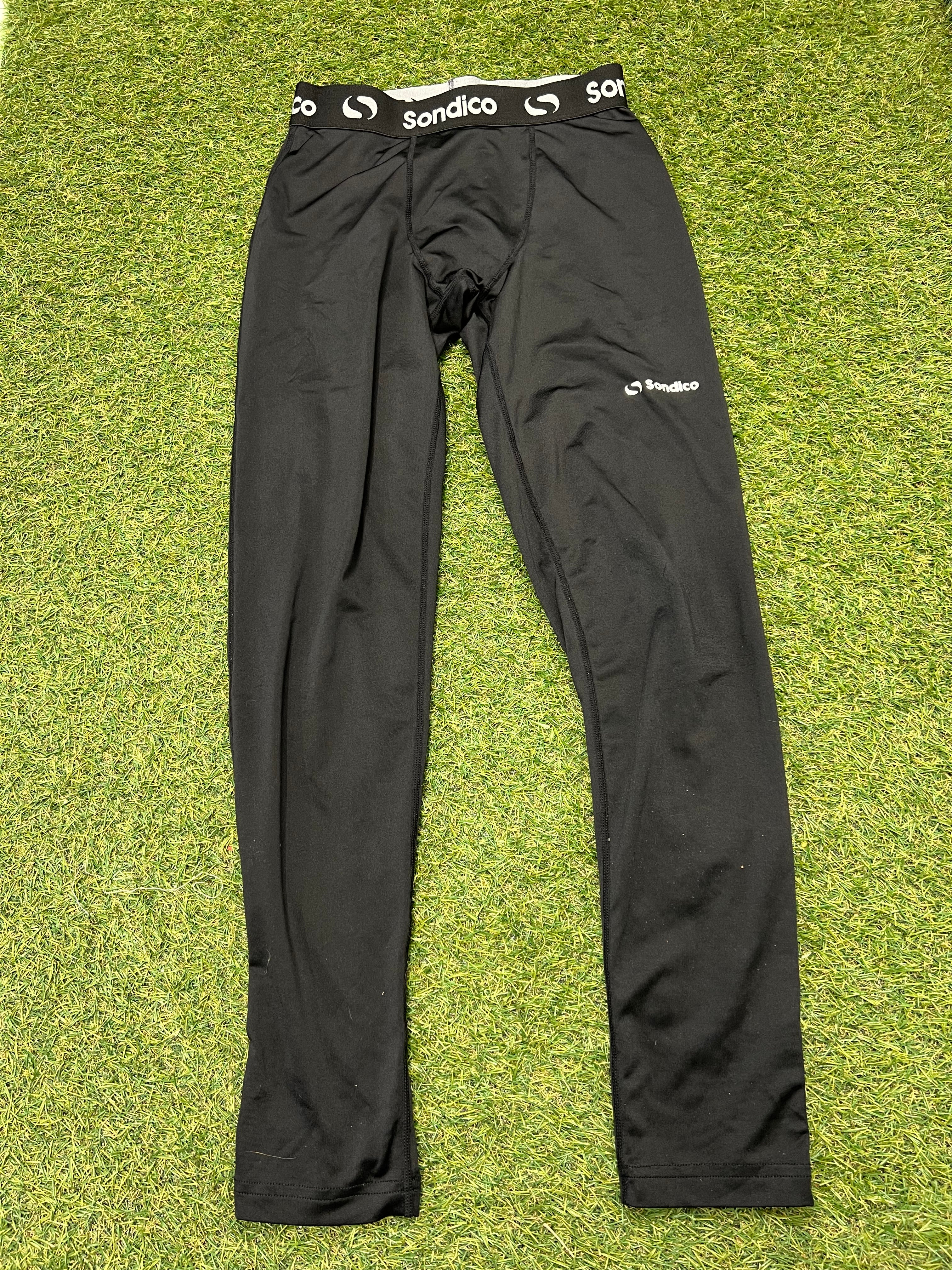 Front view of black Sondico kids base layer leggings showing elastic waistband with logo