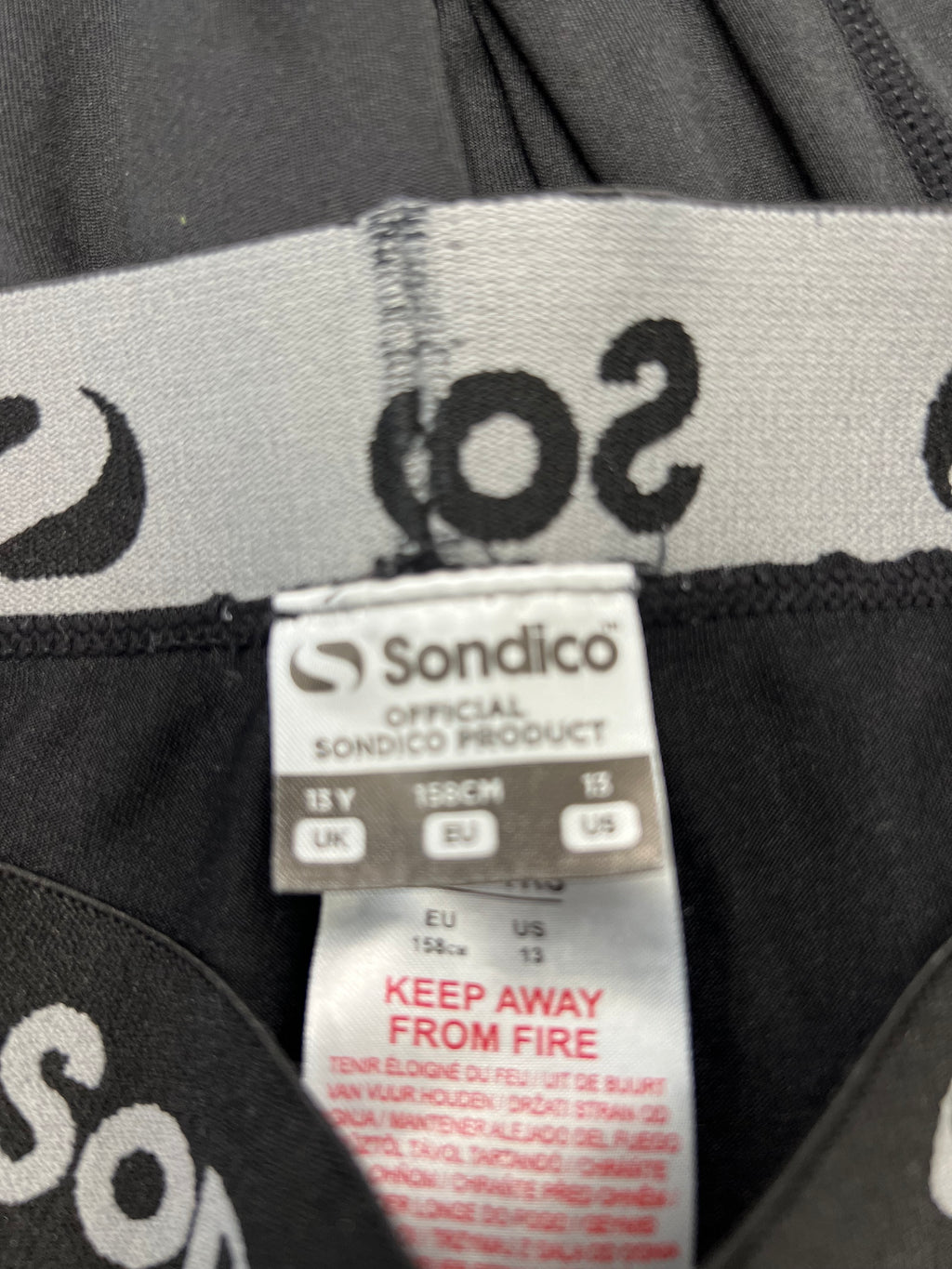 Close-up image of Sondico product label inside base layer leggings showing size 13 years and care instructions