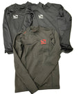 Three Sondico kids' black thermal base layer tops with logos on artificial grass