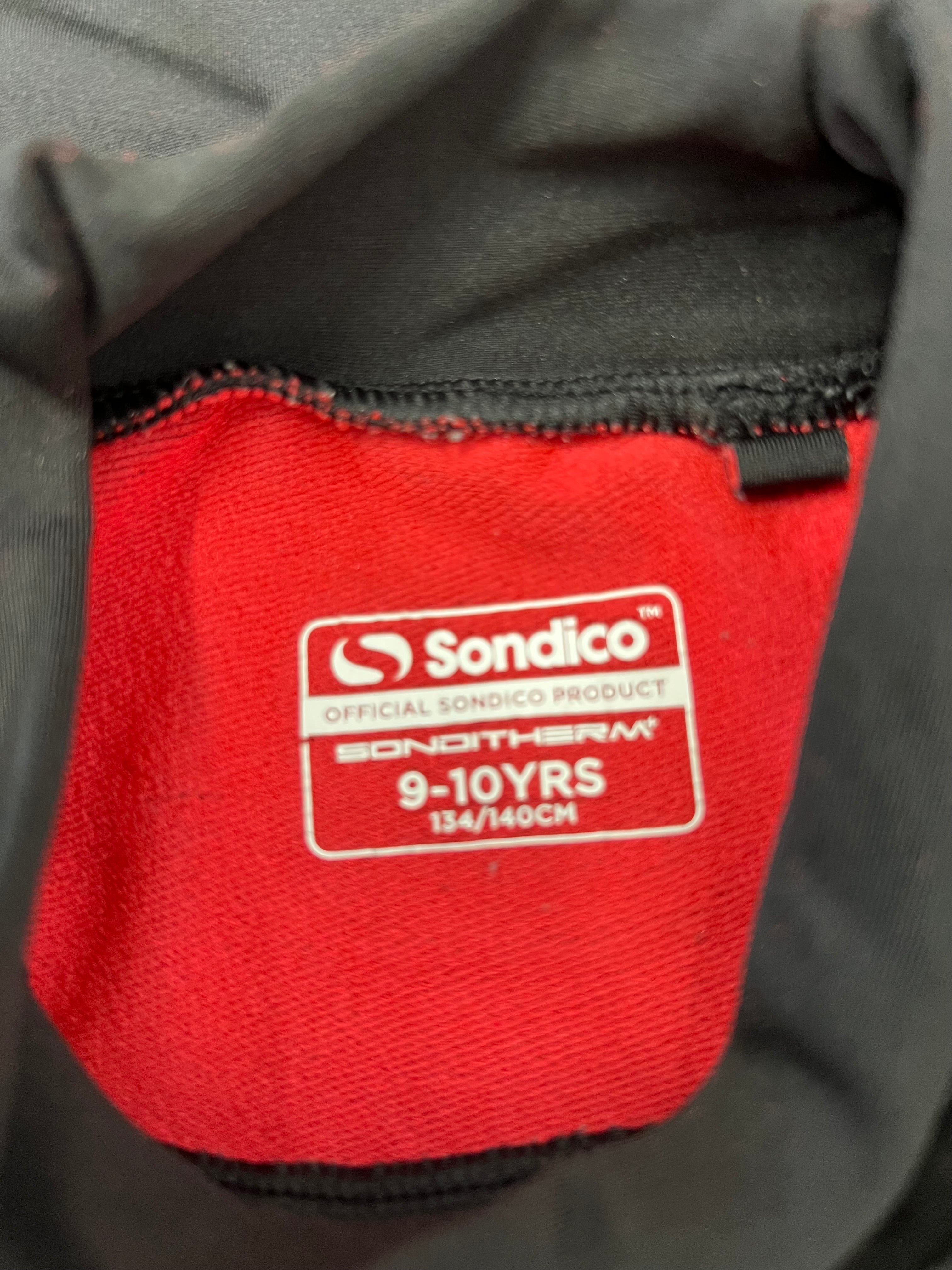 Close-up of red fleece inner lining inside a Sondico kids' thermal top with size label 9-10 years 134/140 cm