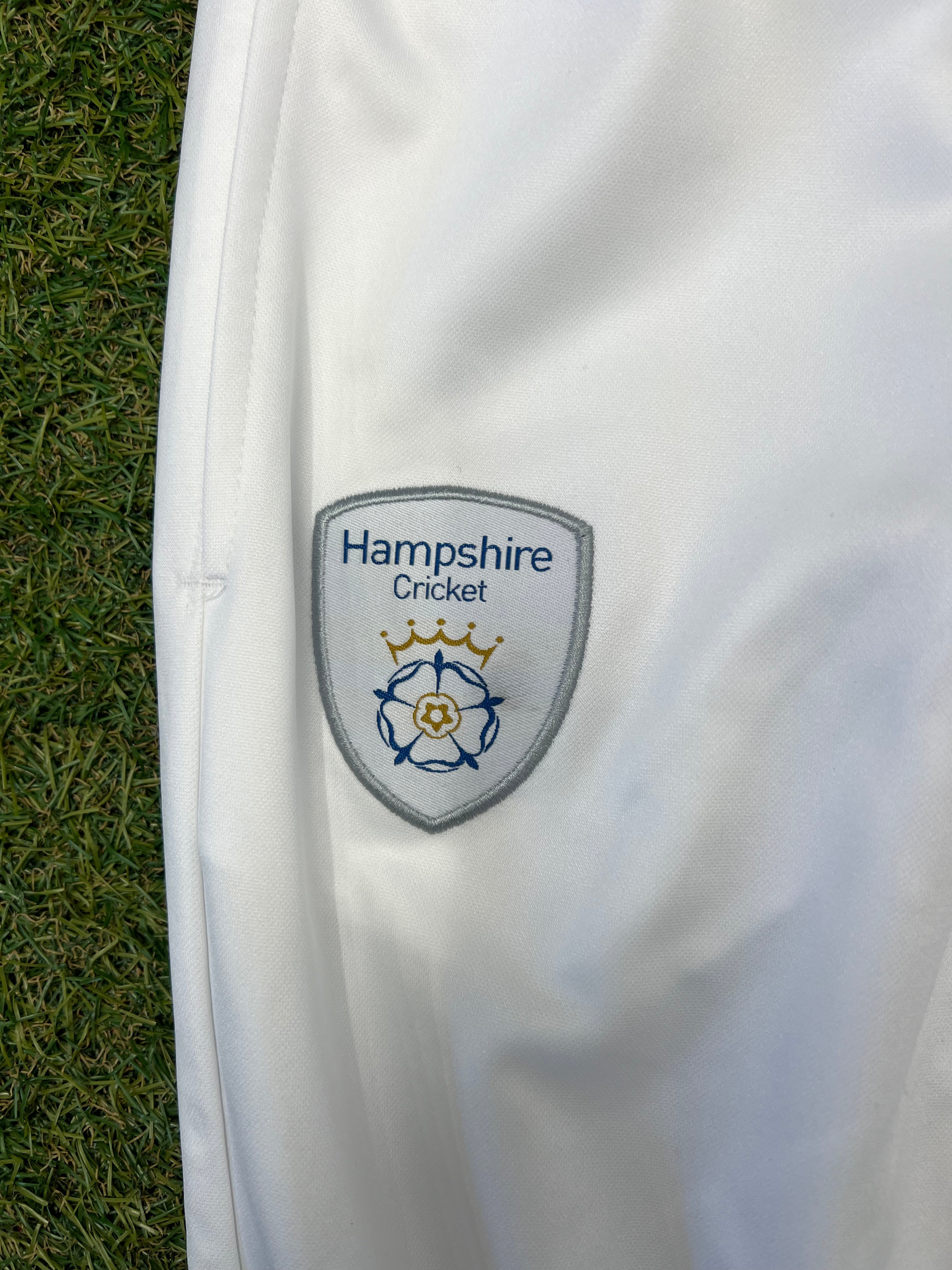 Close-up of Hampshire Cricket Club embroidered badge on white cricket trousers