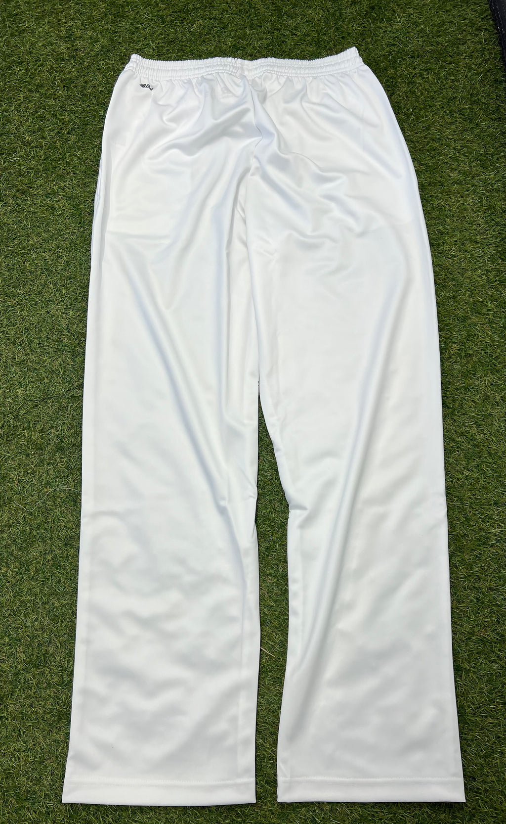 Back view of white New Balance men's cricket trousers showing smooth finish and elastic waistband