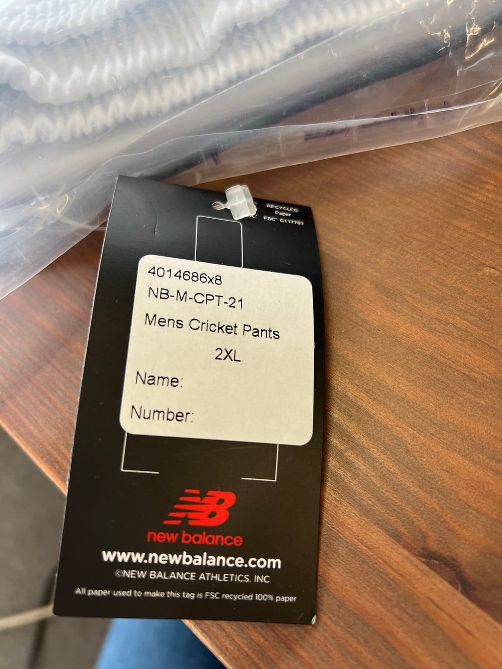 Size and product label on packaging showing New Balance men's cricket trousers size 2XL