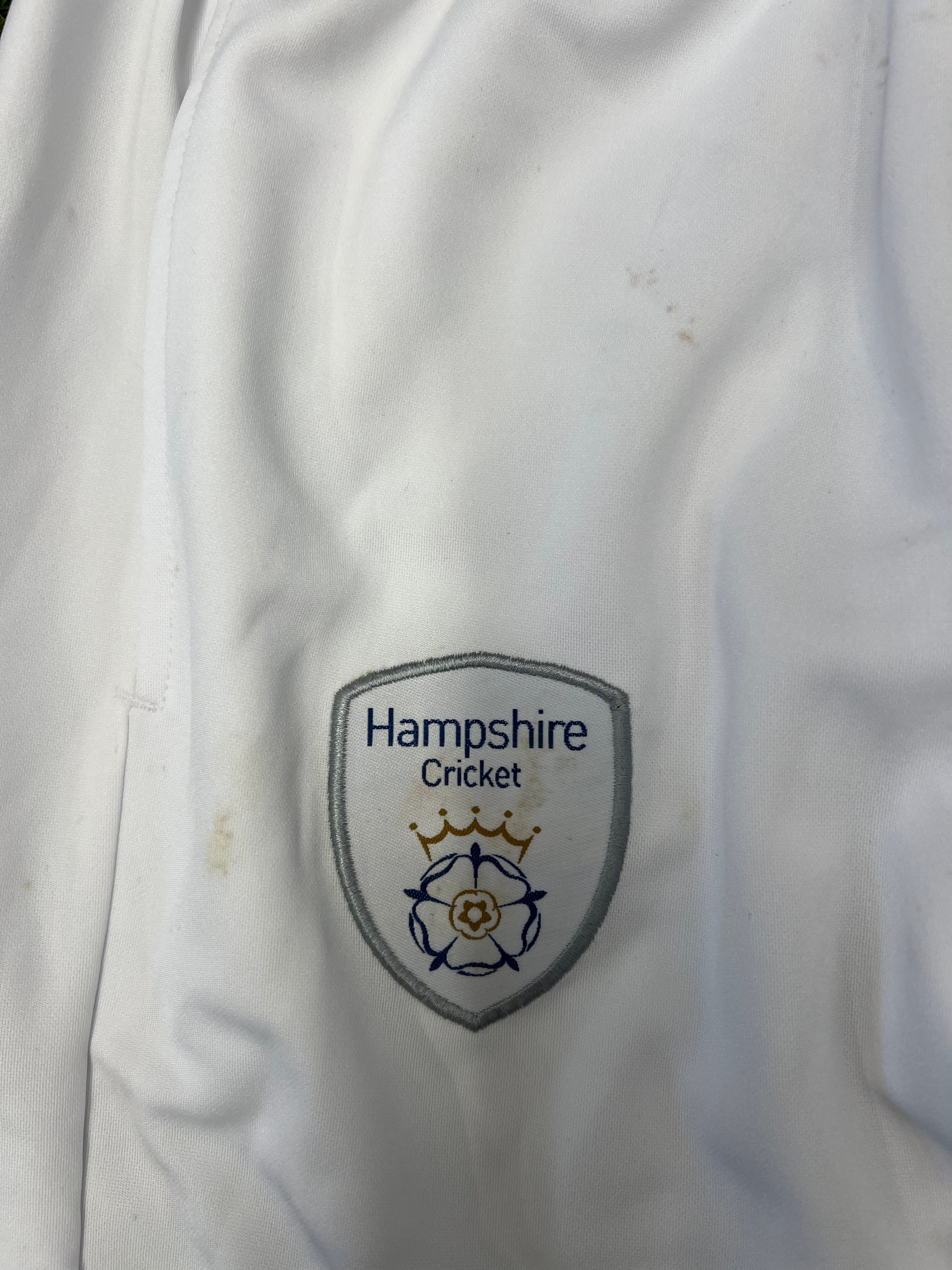 Close-up of Hampshire Cricket Club embroidered badge on white cricket trousers