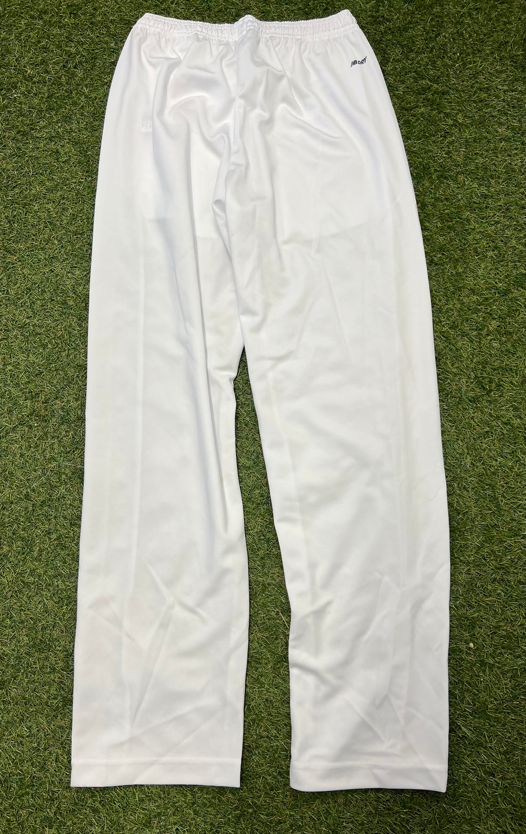 Back view of white New Balance cricket trousers showing elastic waistband