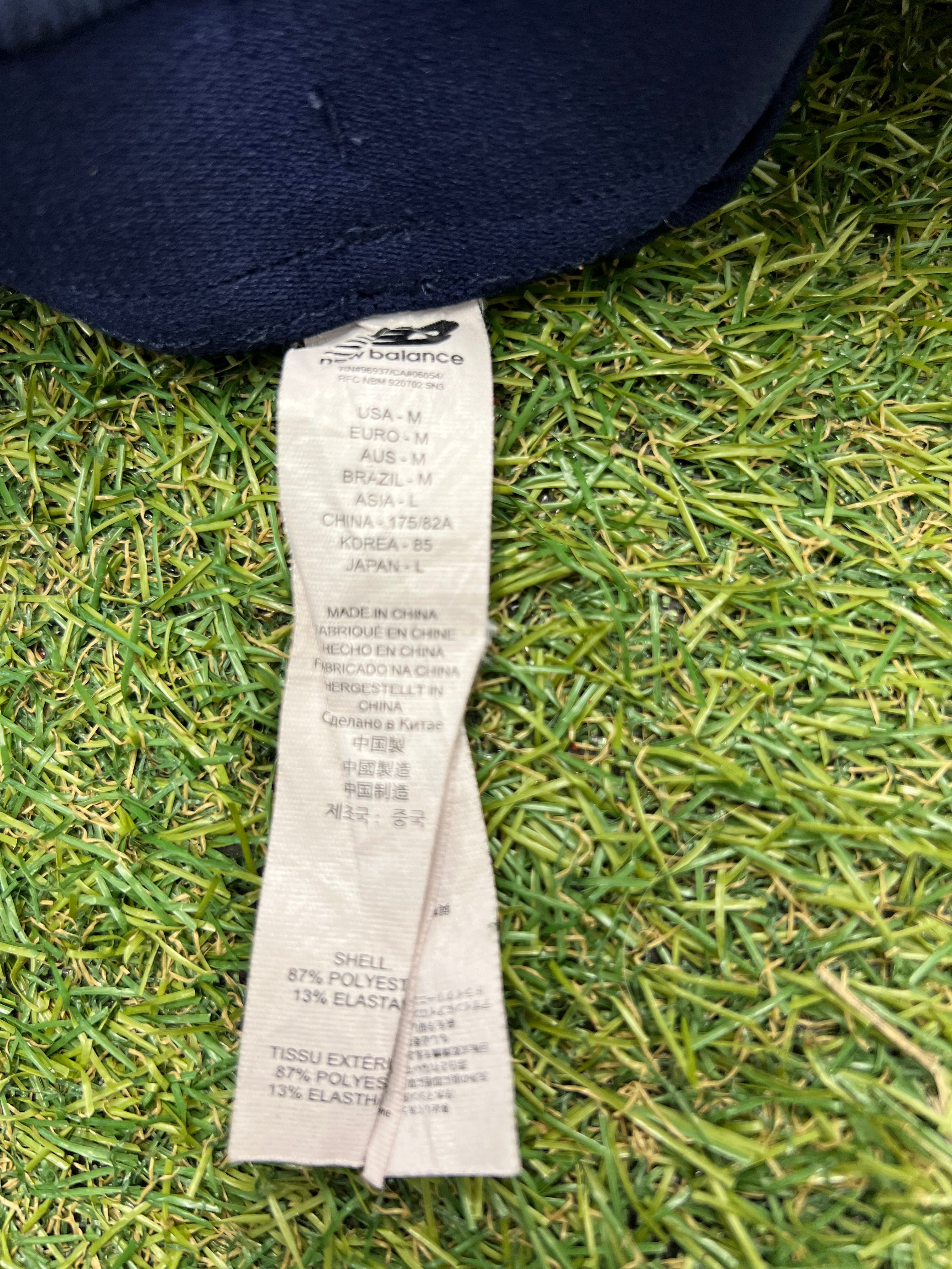 Fabric label of New Balance tracksuit bottoms showing size and material composition