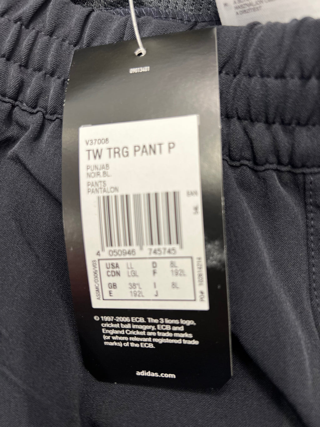 Tag showing product code, size 38”L, and licensing information for Adidas official cricket training trousers