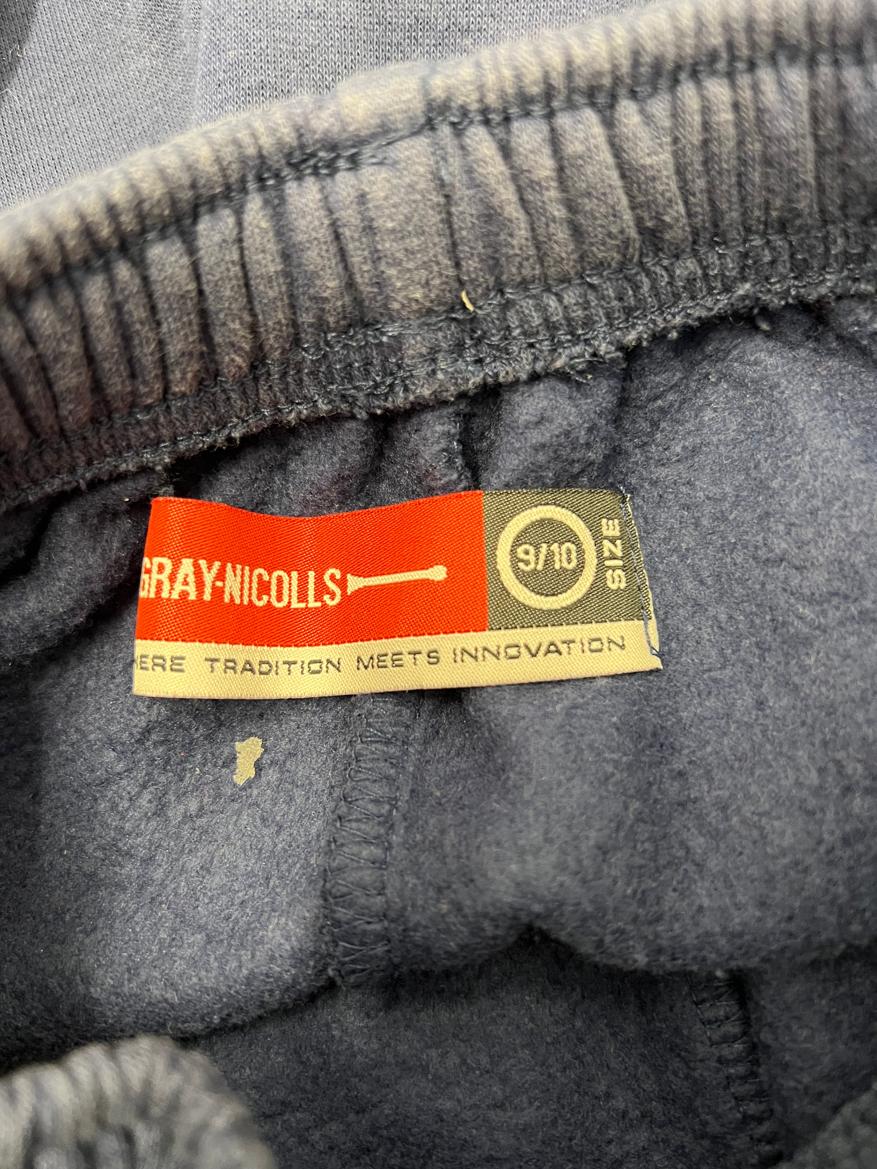 Close-up inside label of Gray Nicolls tracksuit bottoms in size 9/10, soft fleece material visible