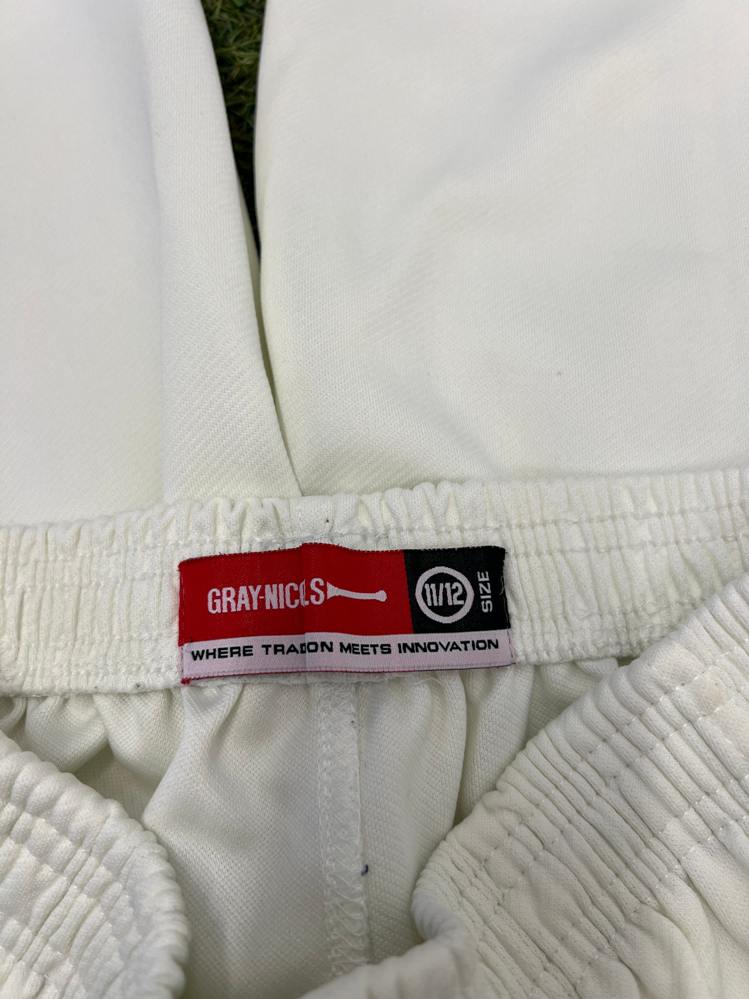 Close-up of Gray-Nicolls brand tag inside the elasticated waistband of white cricket trousers