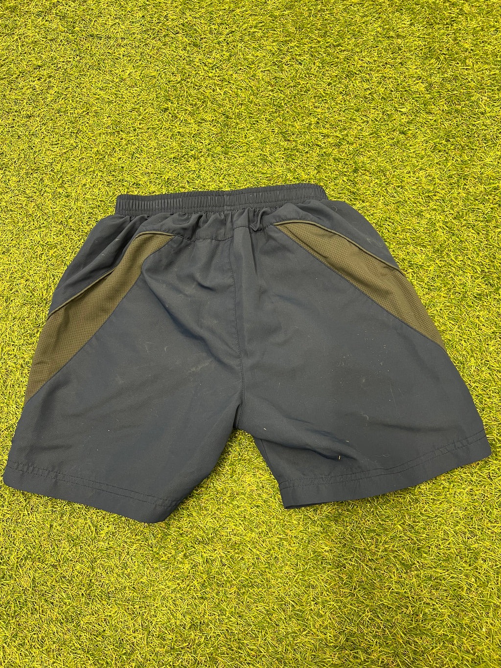 Back view of gray cricket shorts showing elastic waistband and mesh side panels for breathability