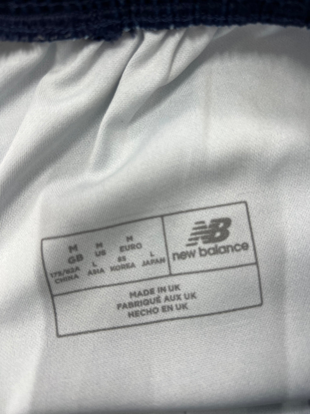 Close-up of New Balance label inside waistband showing size and 'Made in UK' text