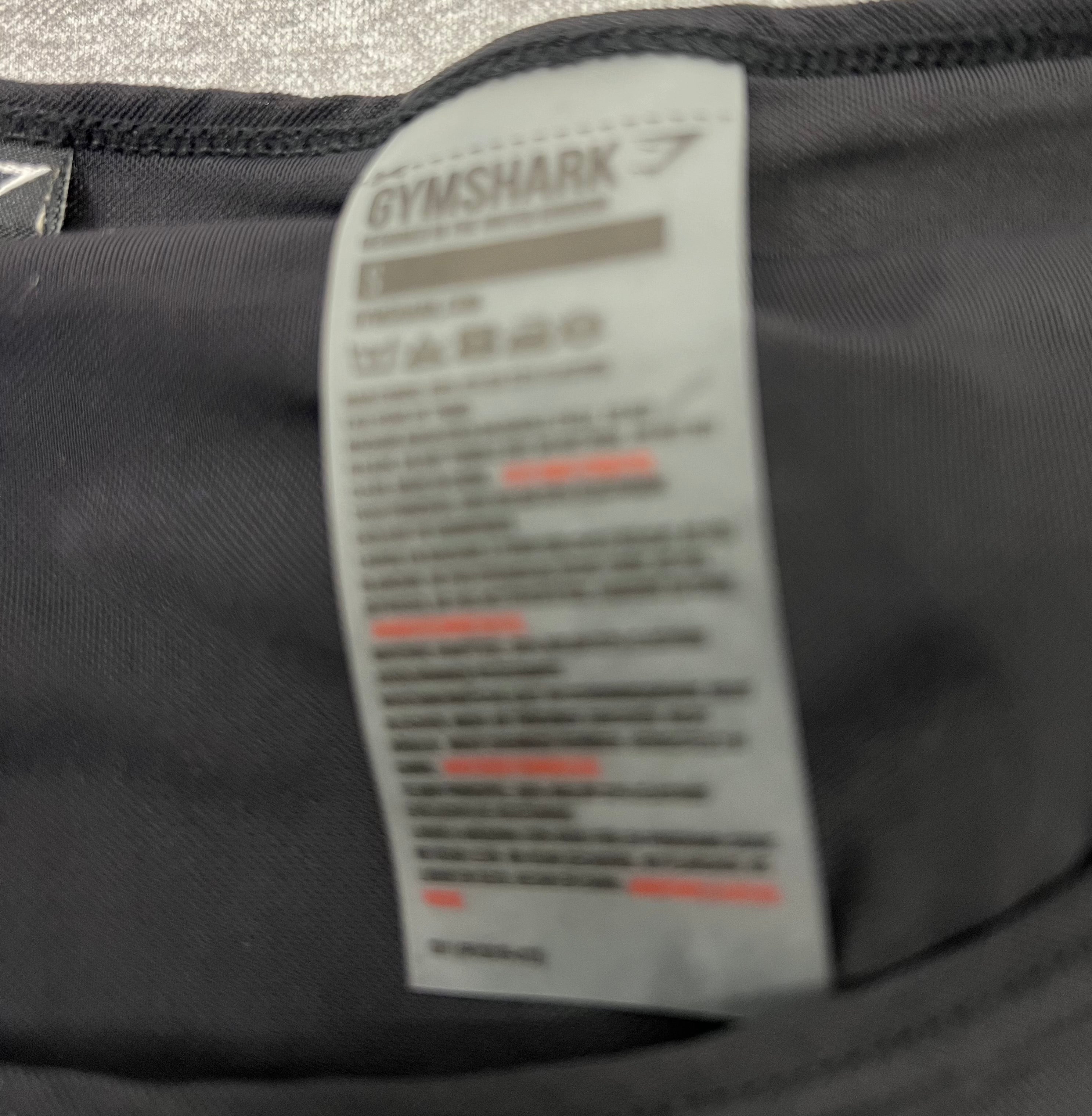 Close-up image of the Gymshark black top’s label showing size small and care instructions