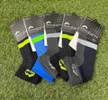 Five pairs of More Mile Preventer Twin Skin Running Socks in assorted colours laid out on grass, showing front packaging