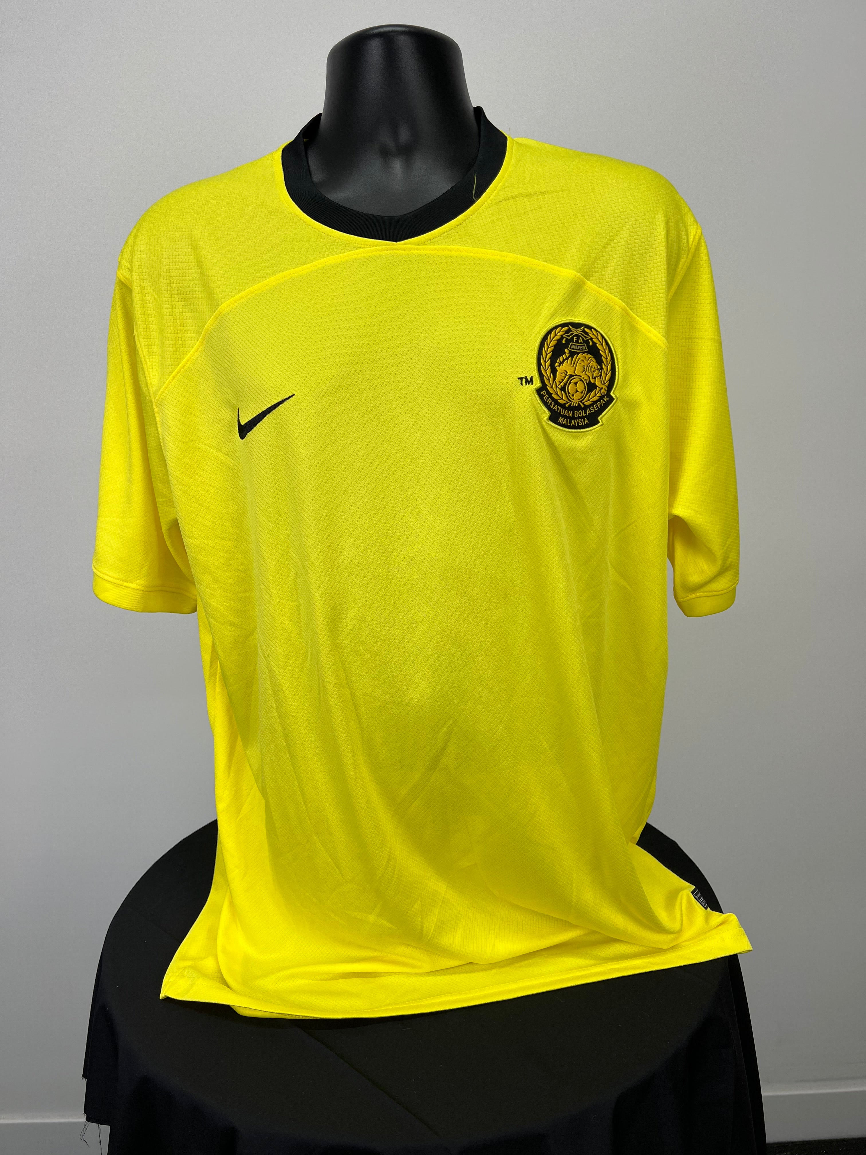 Front view of men's yellow Malaysia football jersey with black Nike logo and team emblem on chest