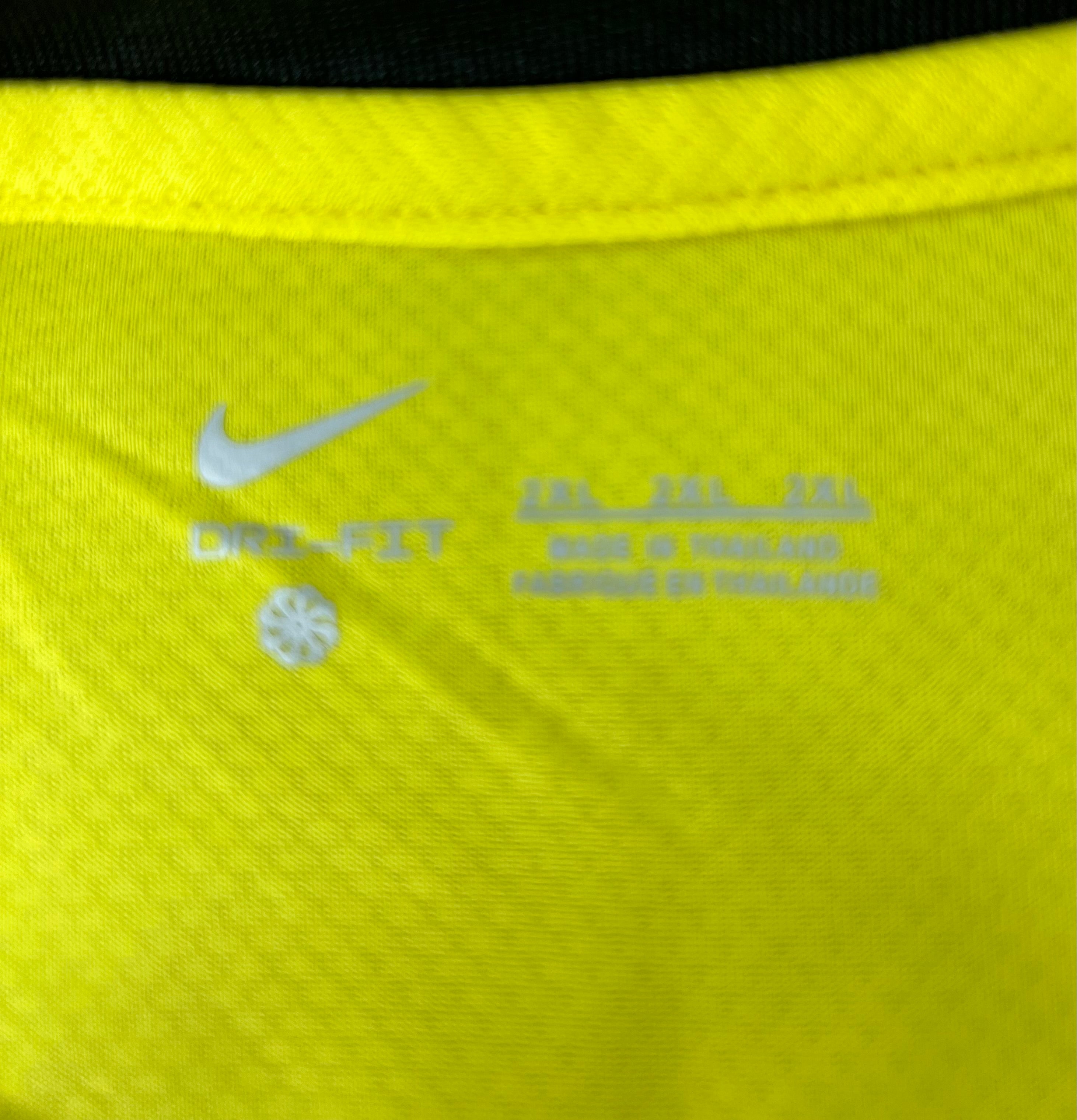 Close-up of Nike Dri-Fit logo and size information printed inside the yellow football jersey