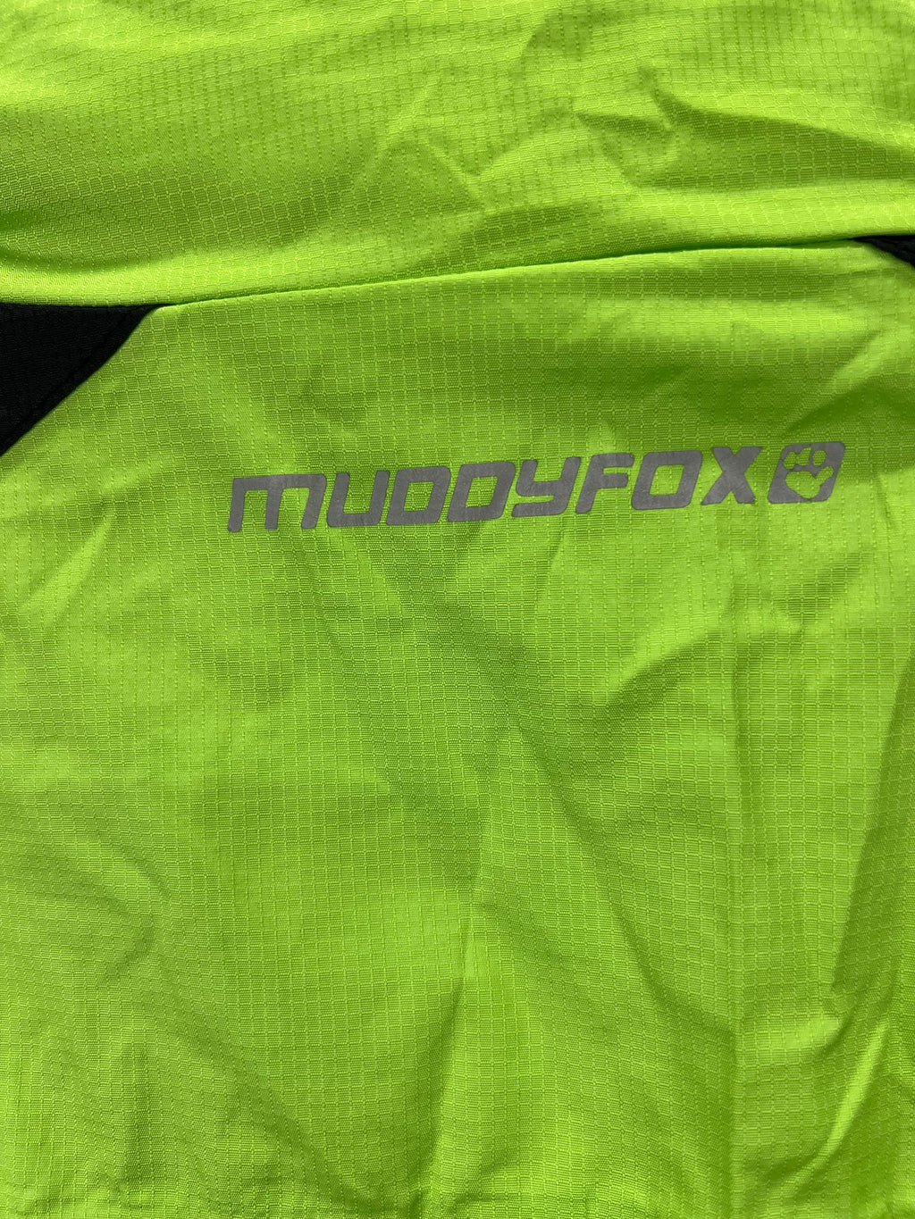 Close-up showing reflective Muddyfox logo on bright green ripstop fabric