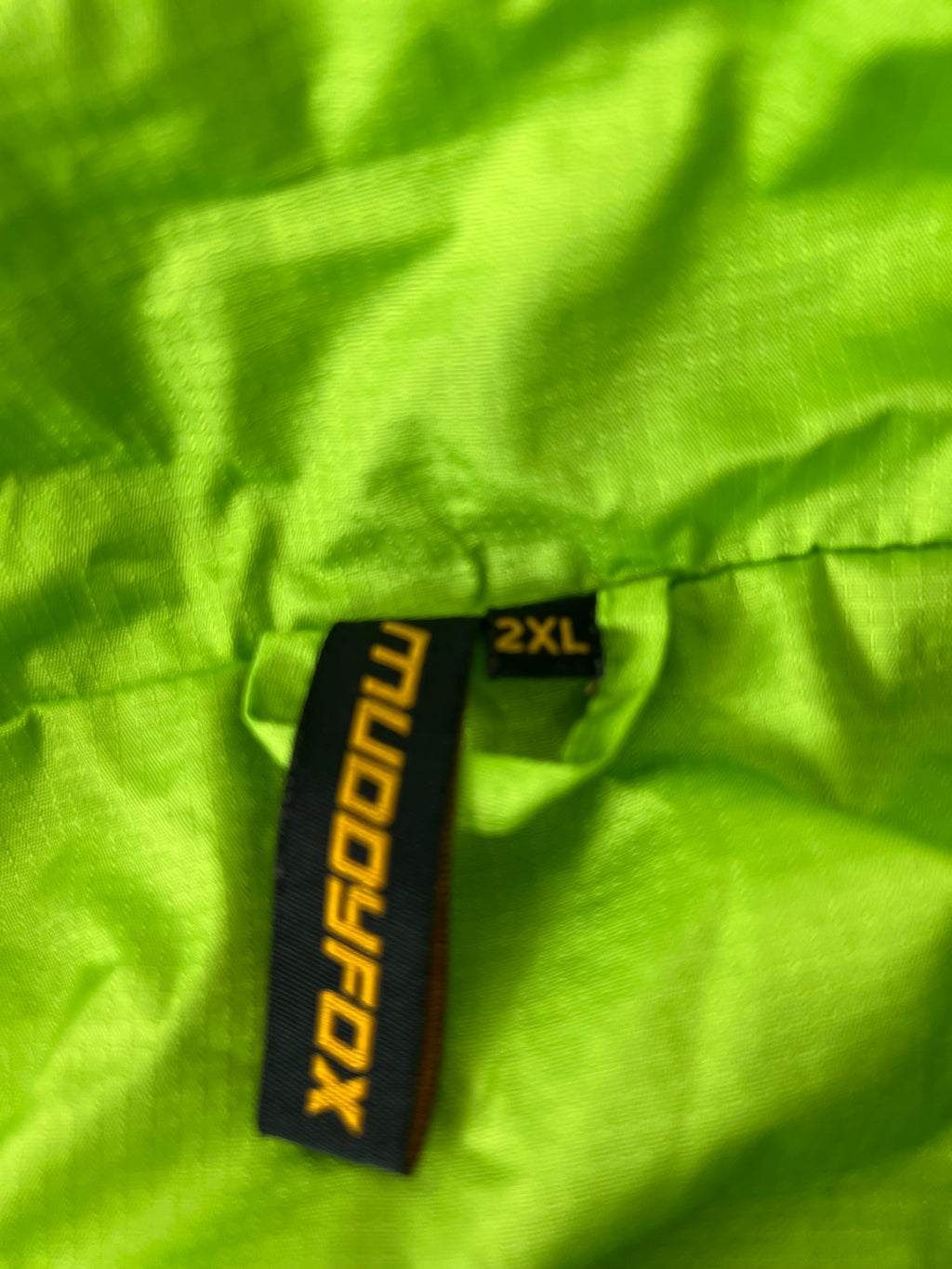 Close-up of size tag indicating 2XL in the collar area of the cycling jacket