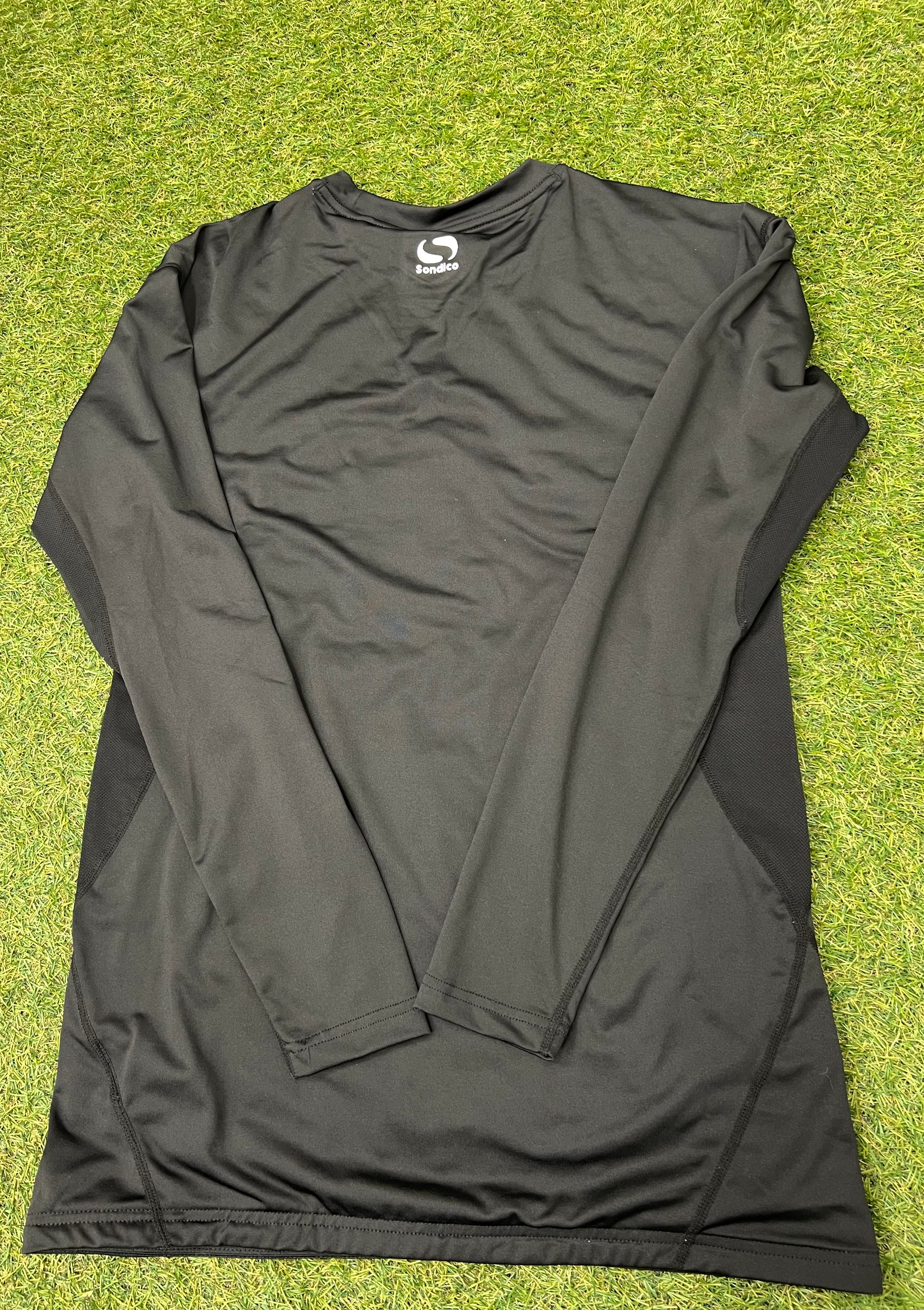 Back view of black Sondico men's long sleeve base layer top laid out flat on grass
