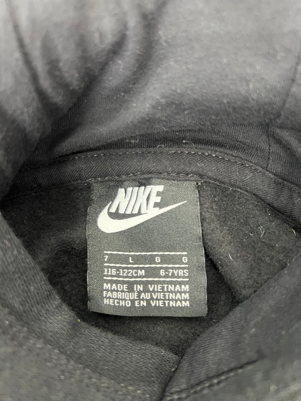 Close-up of the Nike kids' hoodie label showing size 6-7 years and made in Vietnam