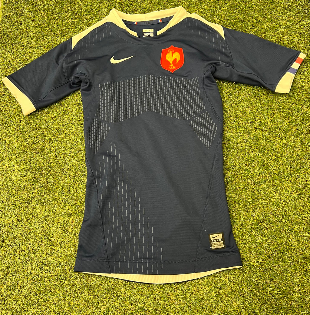 Front side of a black Nike FFR short sleeve rugby jersey with cream accents and red FFR emblem on chest
