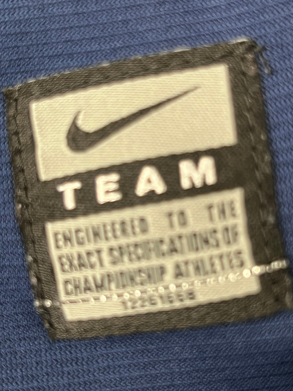 Close-up of the Nike TEAM quality stitched label highlighting engineered performance for athletes