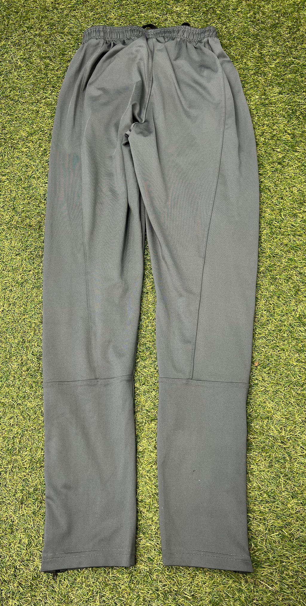 Close-up of grey tracksuit trousers ankle with zipped closure partially opened