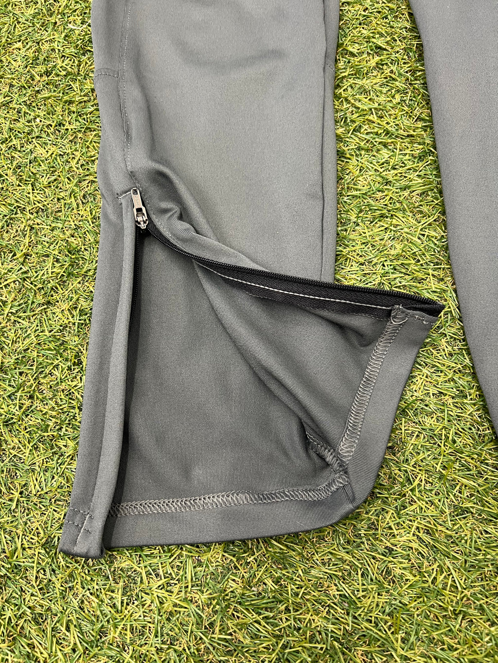 Close-up inside label on grey Under Armour tracksuit trousers showing size and brand info