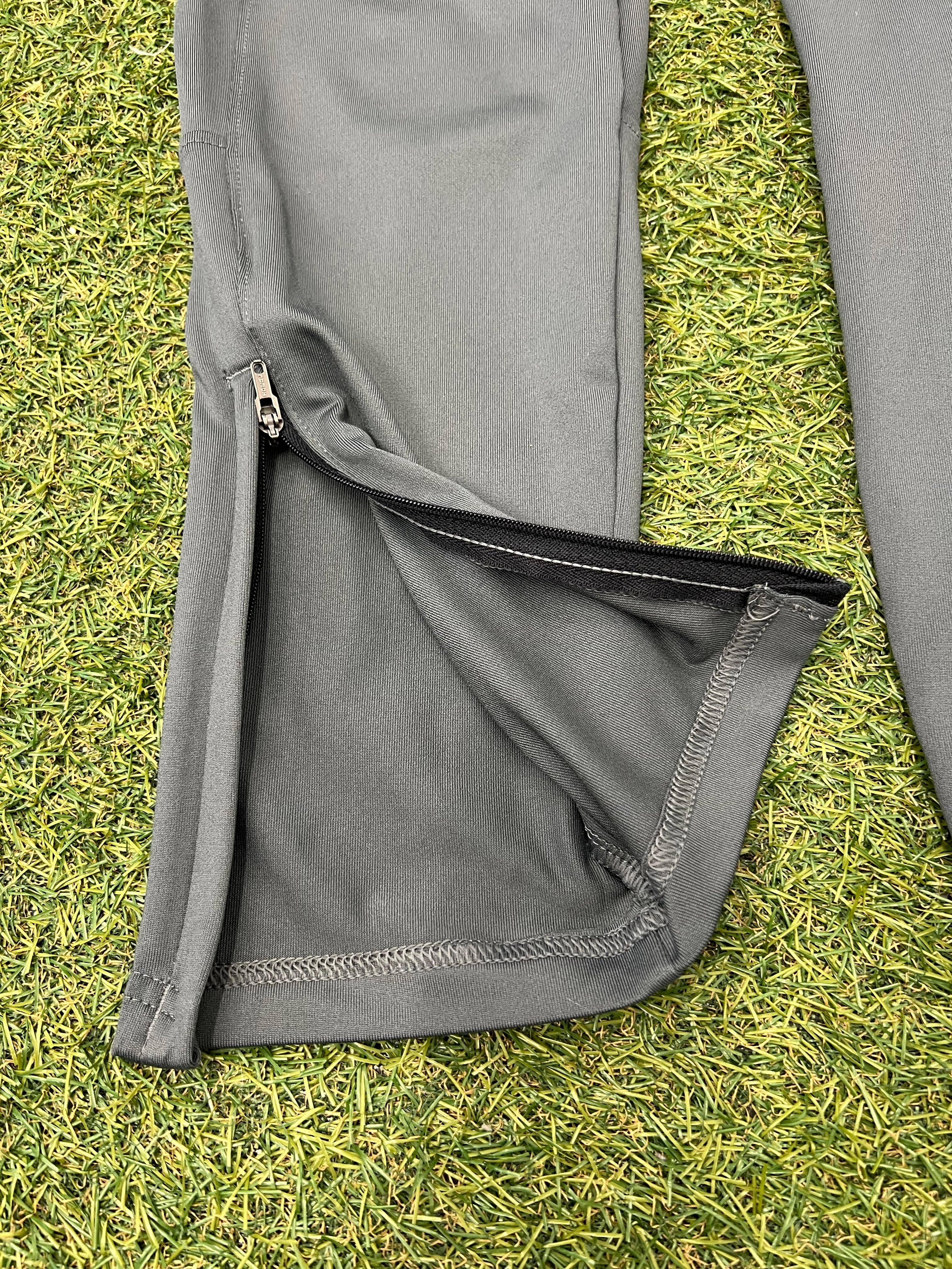 Close-up inside label on grey Under Armour tracksuit trousers showing size and brand info