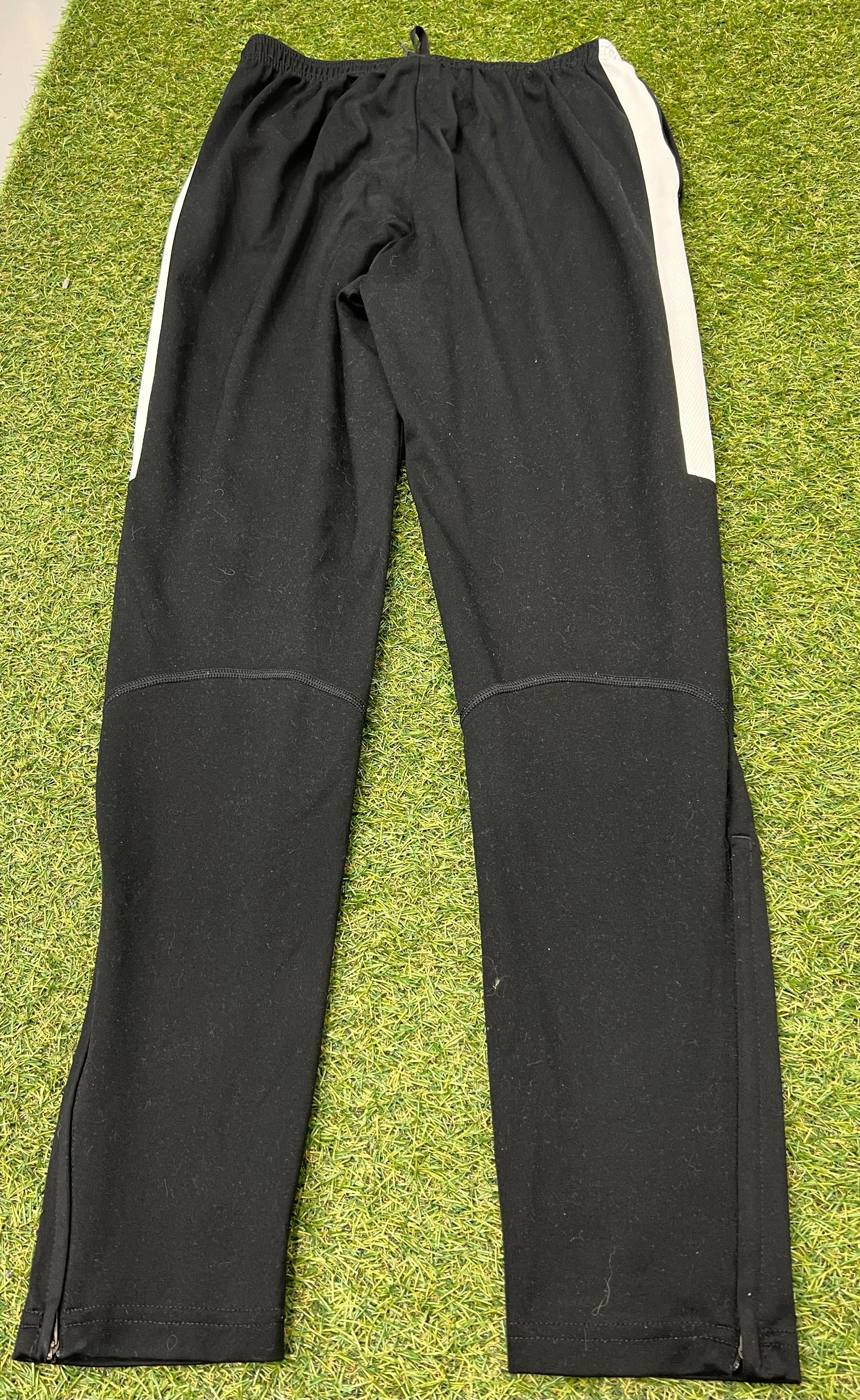 Back view of Nike black tracksuit bottoms showing elastic waistband and white side panels
